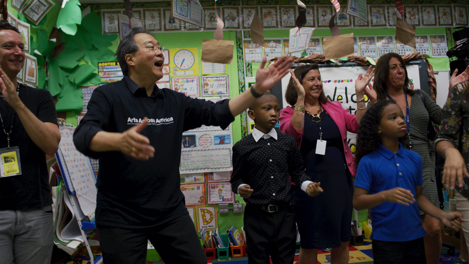 The Kennedy Center Group of children with adults celebrating in a classroom