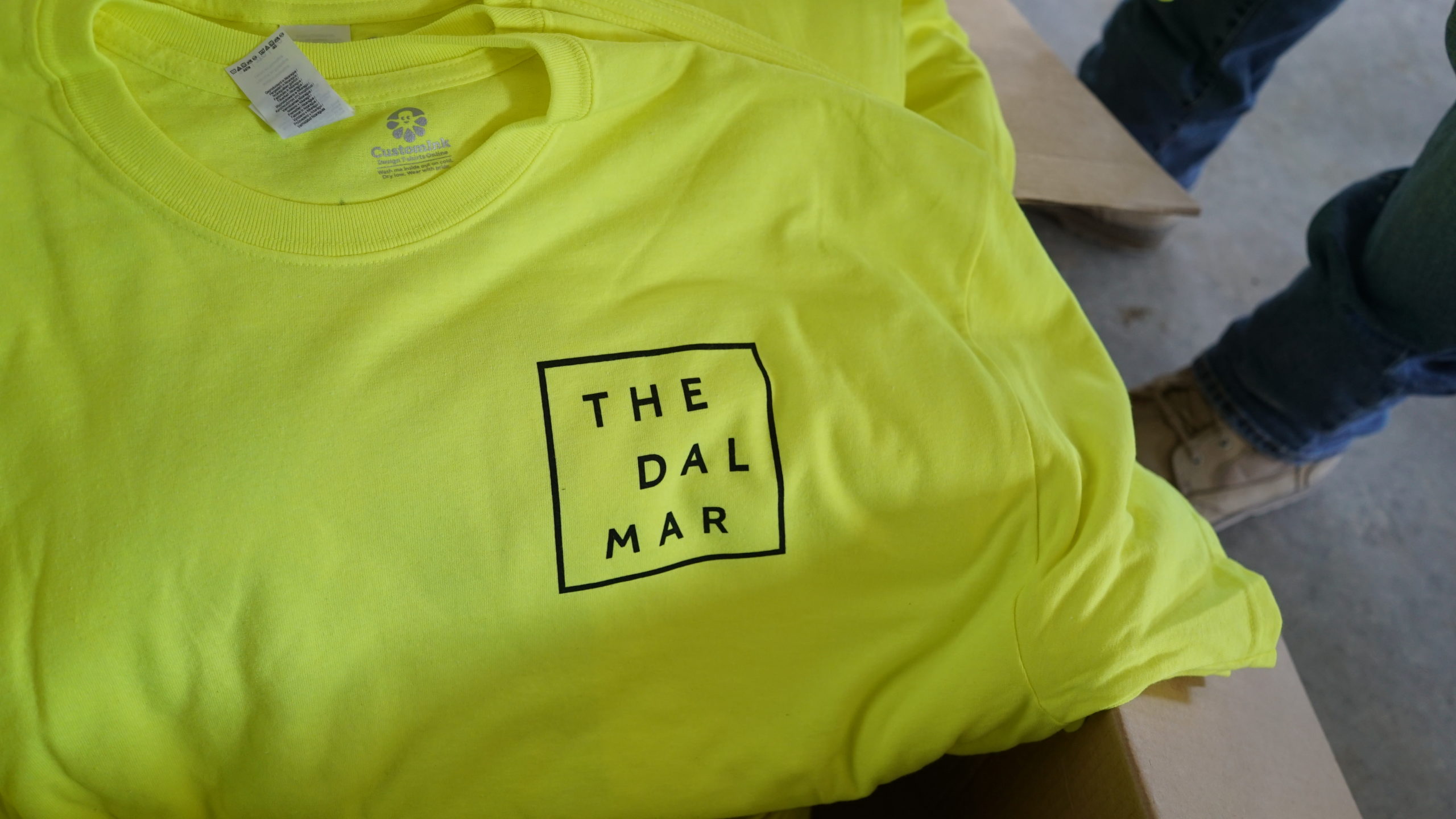 Display of a neon tshirt with the label The Dal Mar