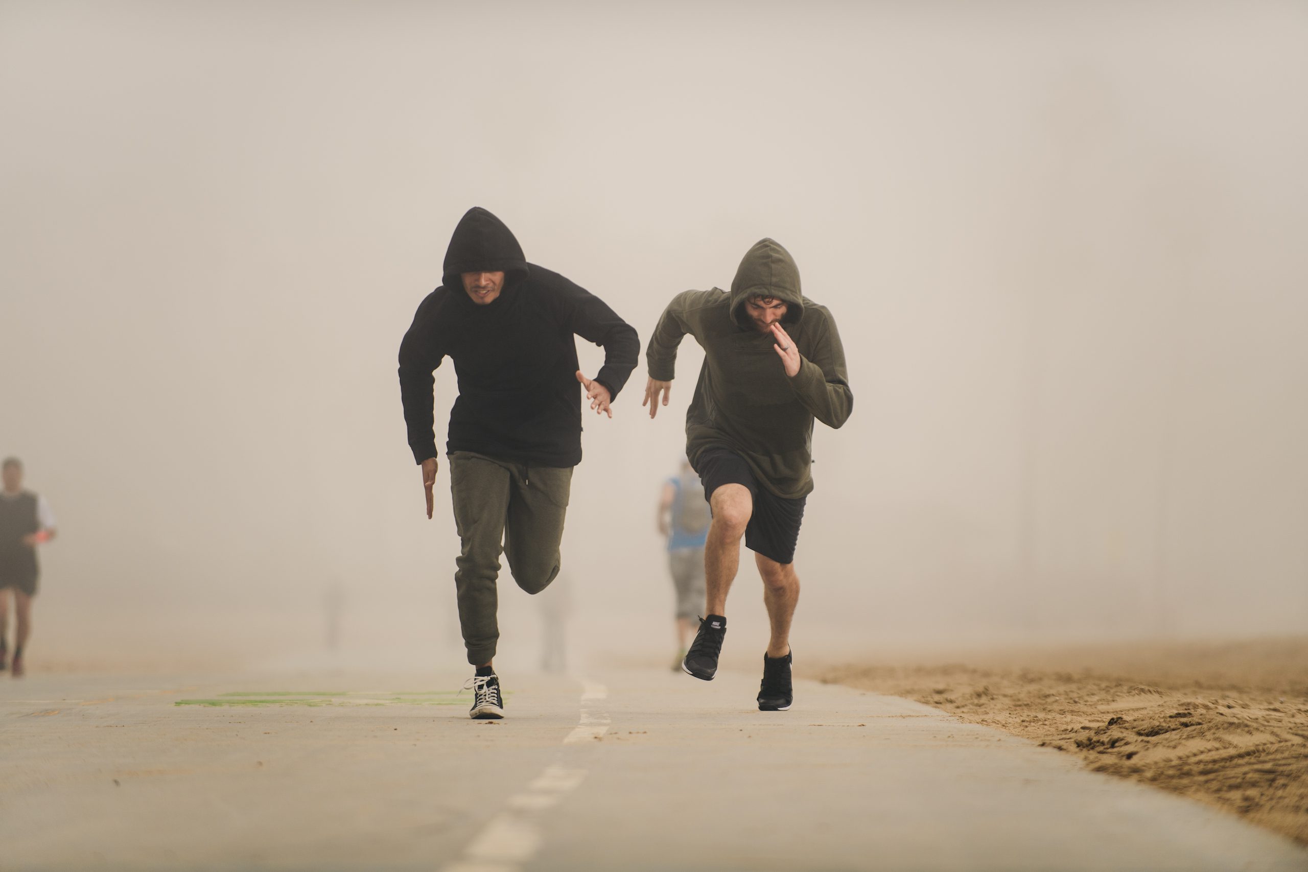 IU C&I Studios Portfolio Health and Fitness Marketing Kinetix 365 Beach Exercises Two mean wearing hoodies running down a path