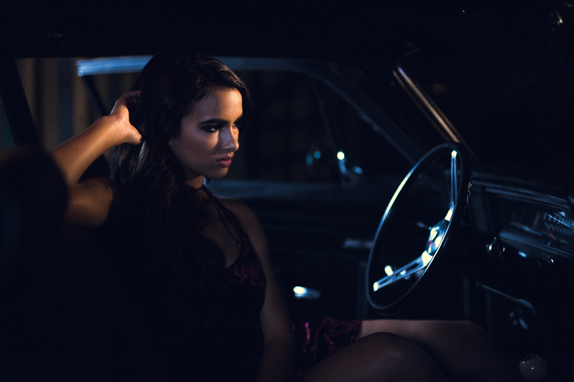 Creative Talent Agency Fort Lauderdale Model Profile Mercedes Side profile of woman with long hair wearing lingerie posing for camera from the front seat of an old car looking out the windshield