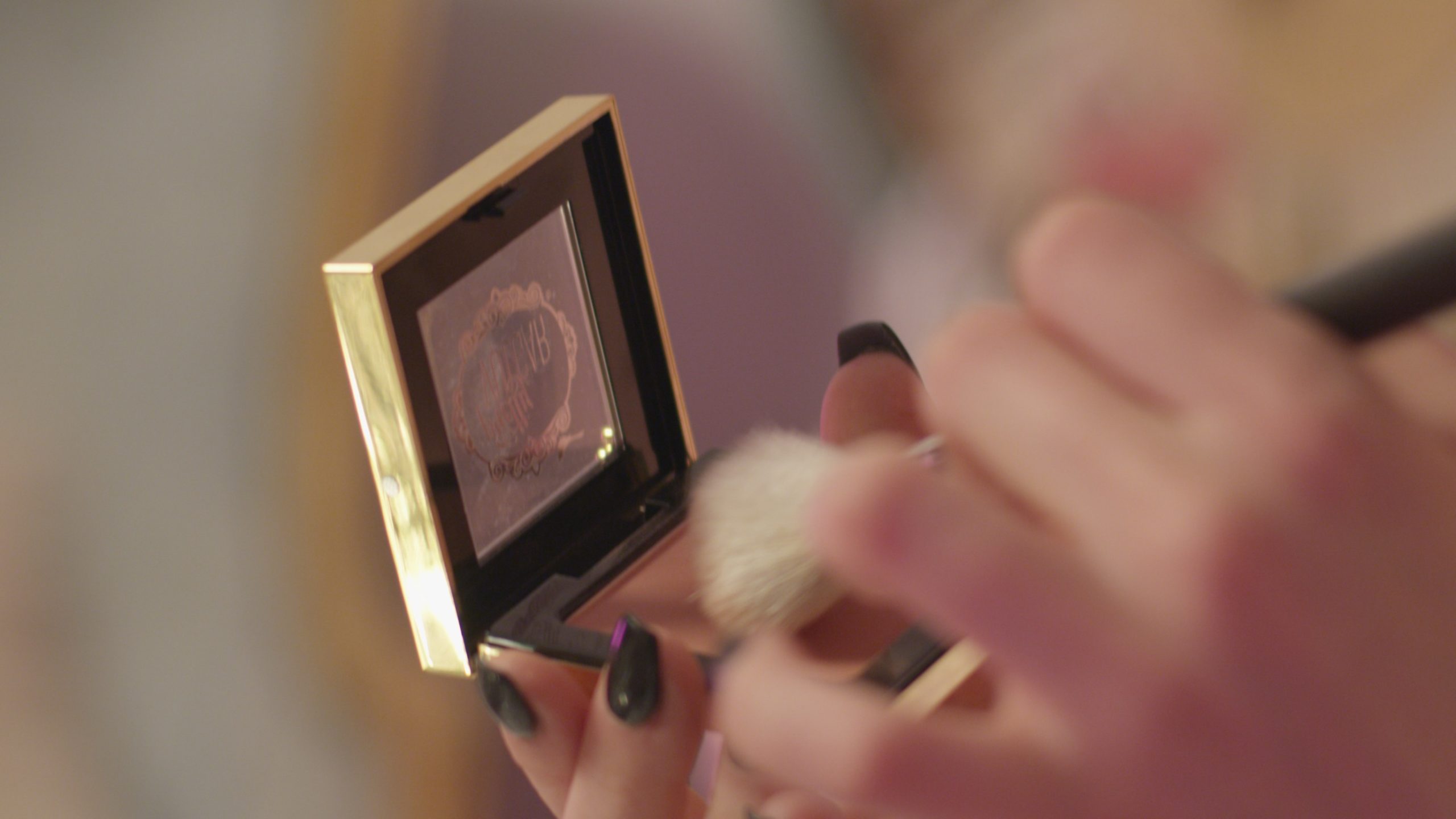 Video Production with Pretty Vulgar-Closeup of black nail polish hand-held makeup kit with brush.