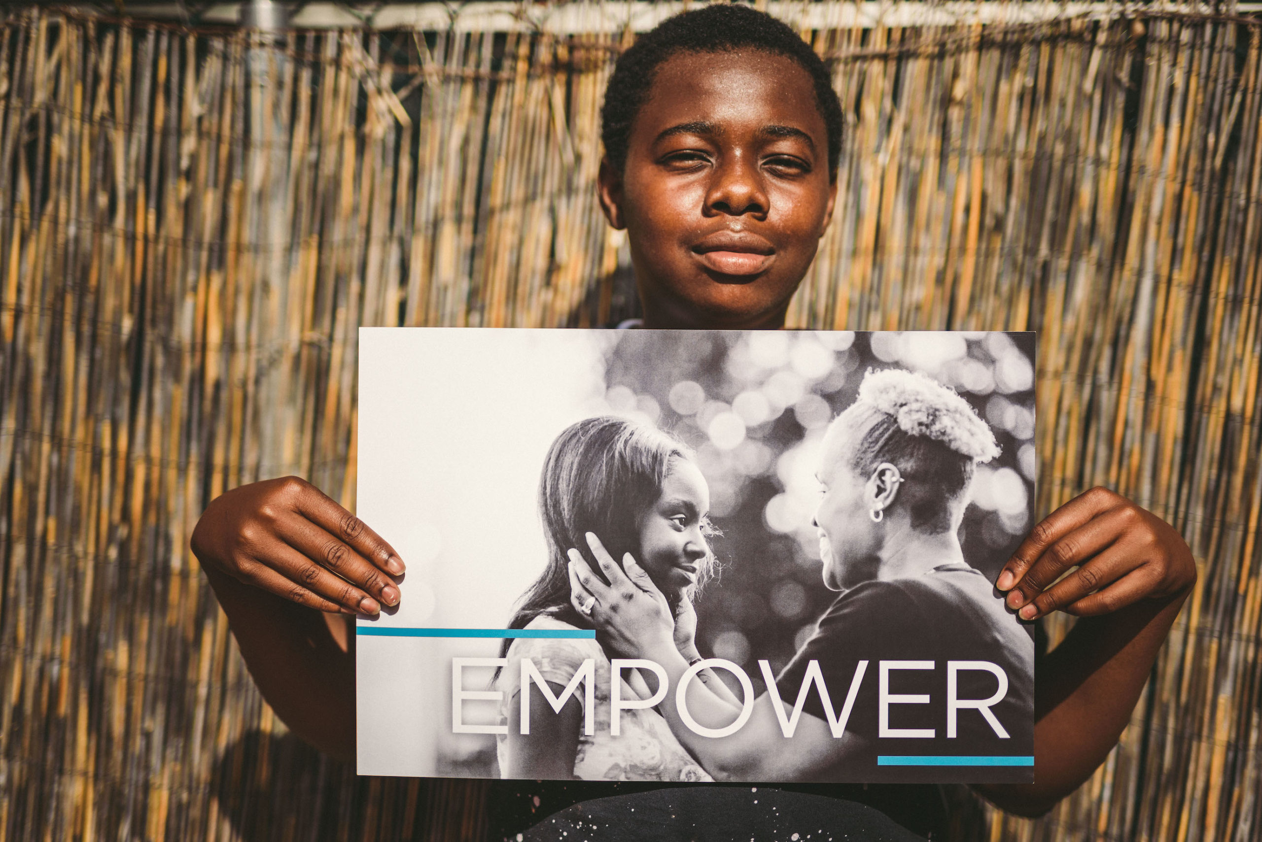 Handy Nonprofit African American holding a black and white poster that shows two people with the word Empower