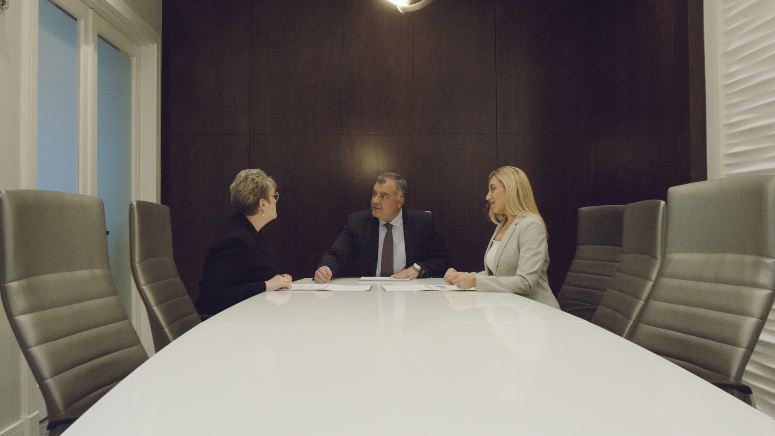 Hightower Financial Advisors A man and two women gathered at an office table having a discussion