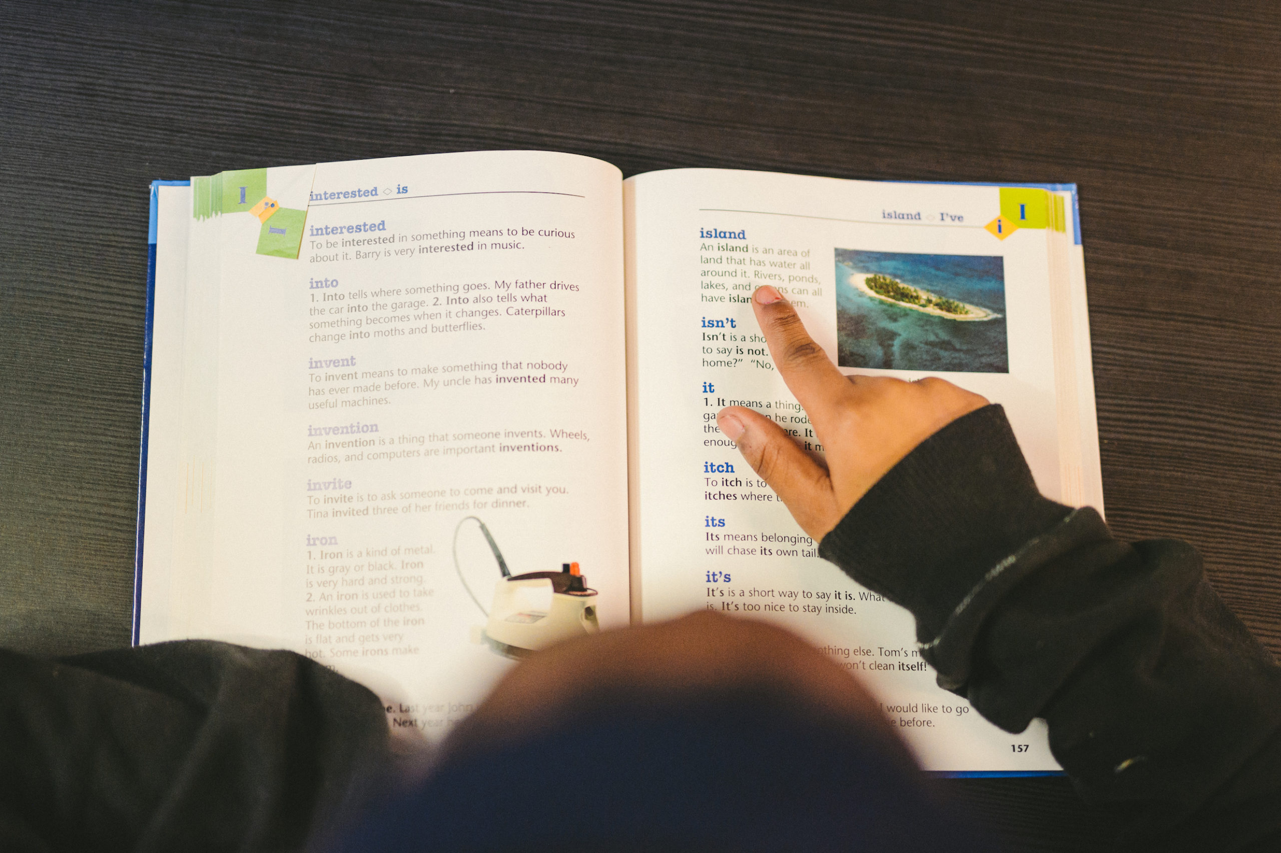 IKD Overhead view of a student pointing to an island definition entry in a book