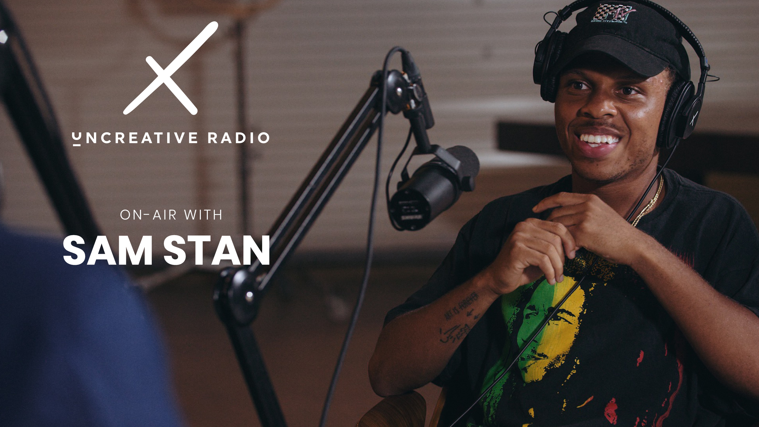 IU C&I Studios Page Uncreative Radio with Sam Stan Headshot of African American man wearing black headphones and black cap talking in microphone