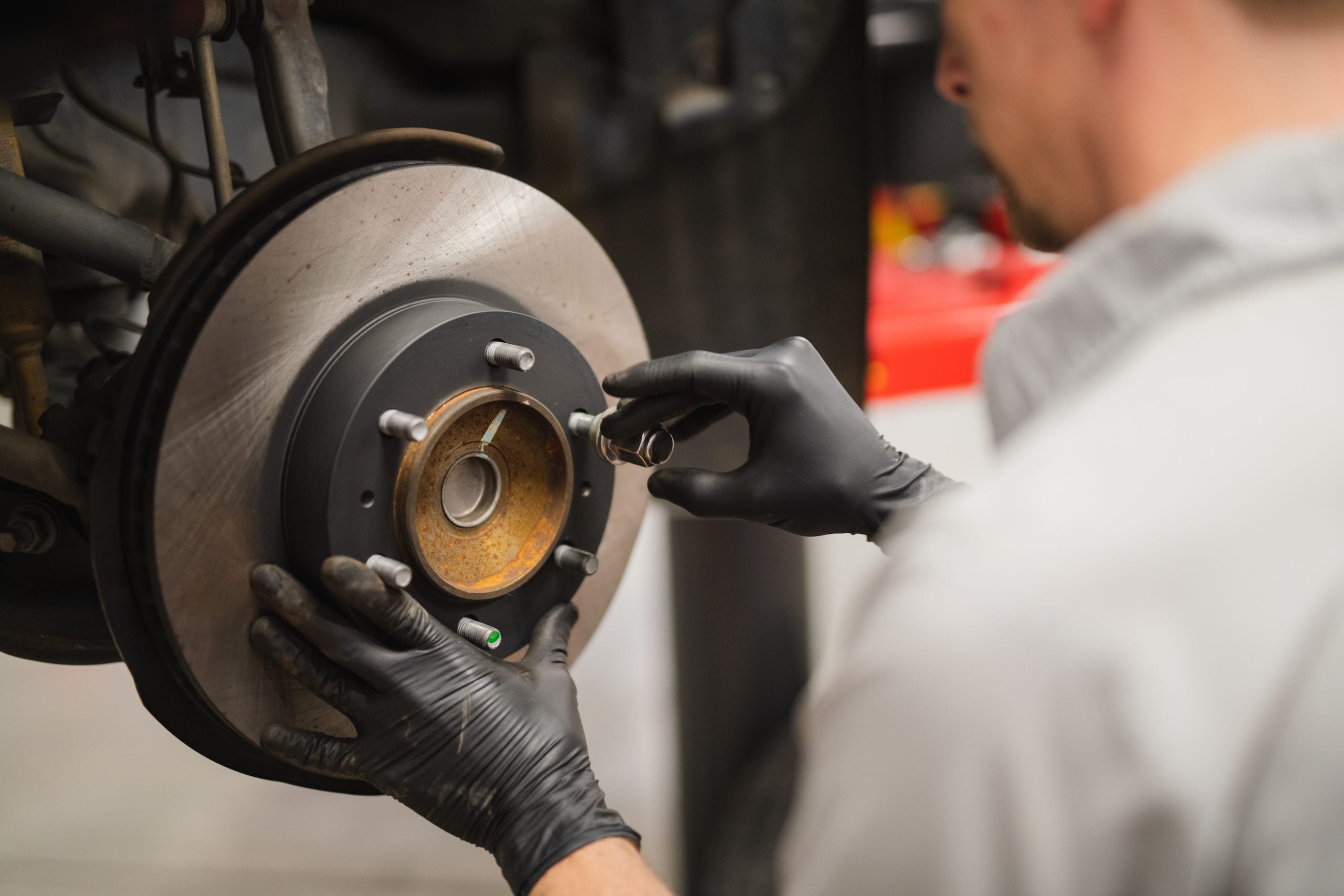 Mechanic working on brakes of a car in a garage