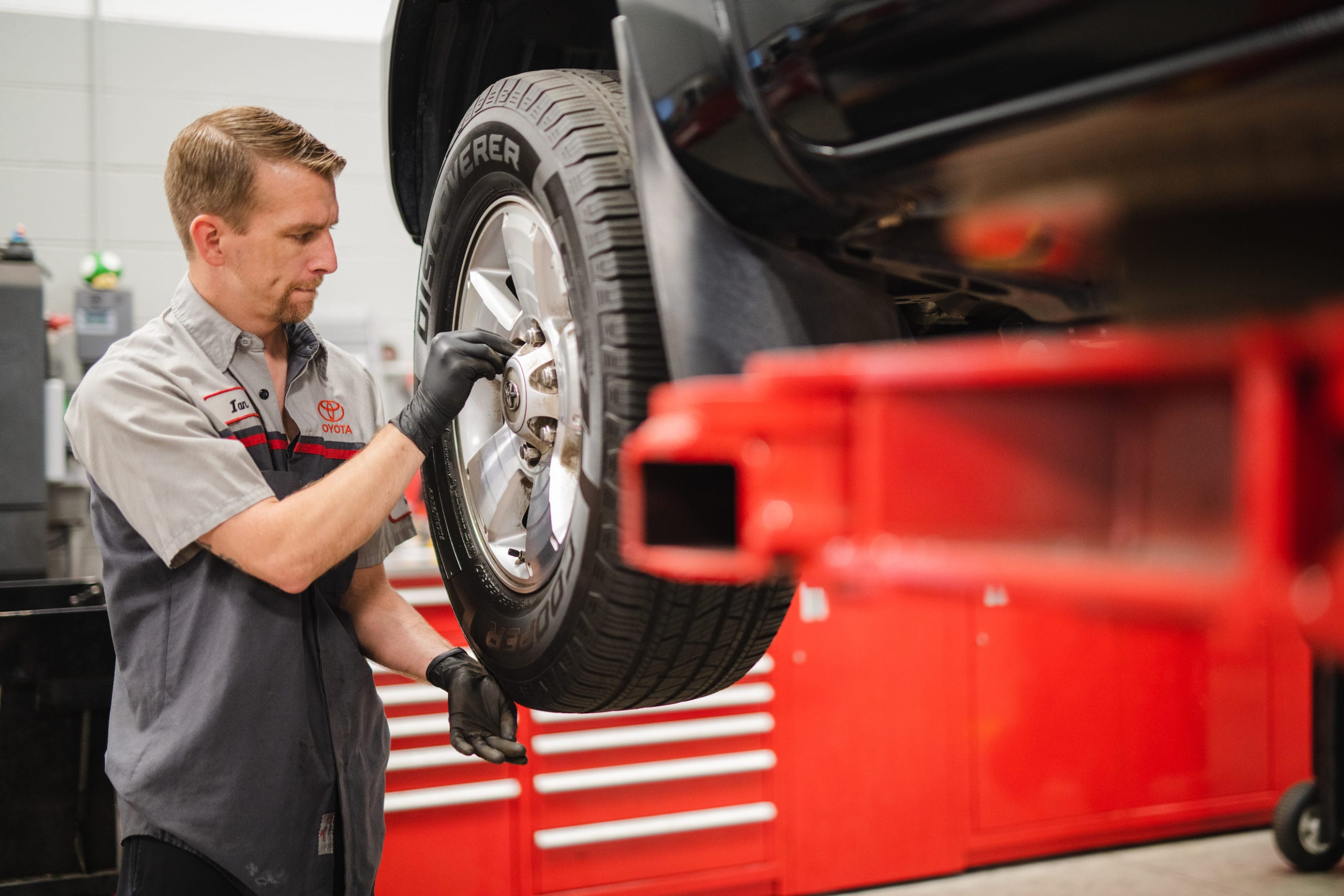 Mechanic working on tire of a car in a garage