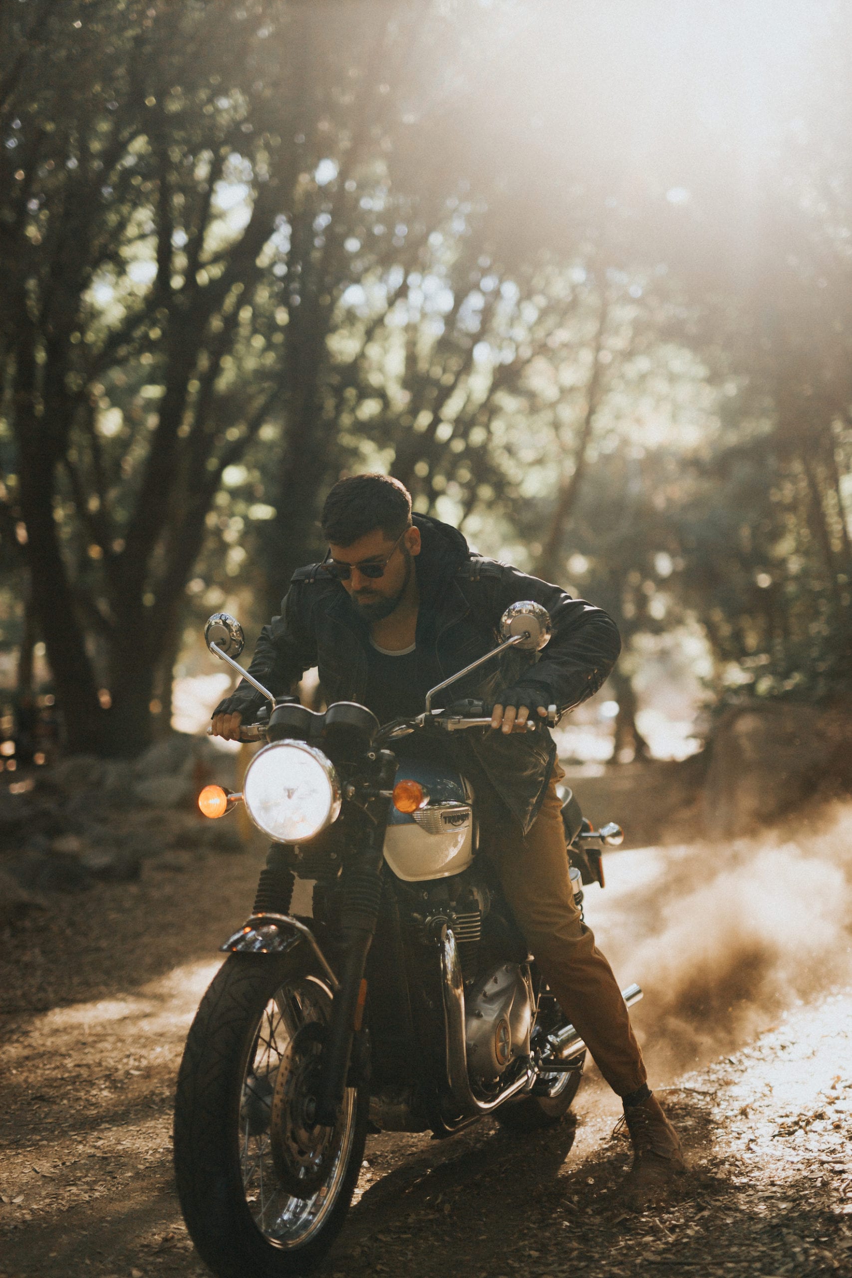 Motorcycle rider wearing shades sitting on the motorcycle posing for the camera