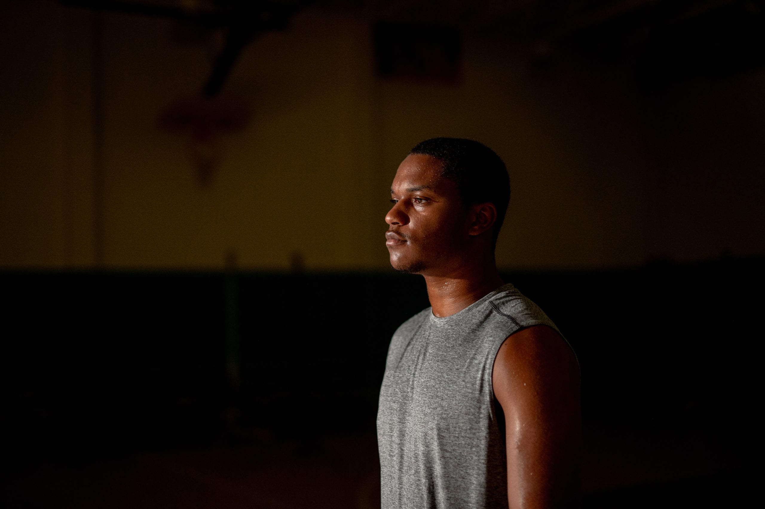 Nike Side profile headshot of African American man wearing a gray t shirt