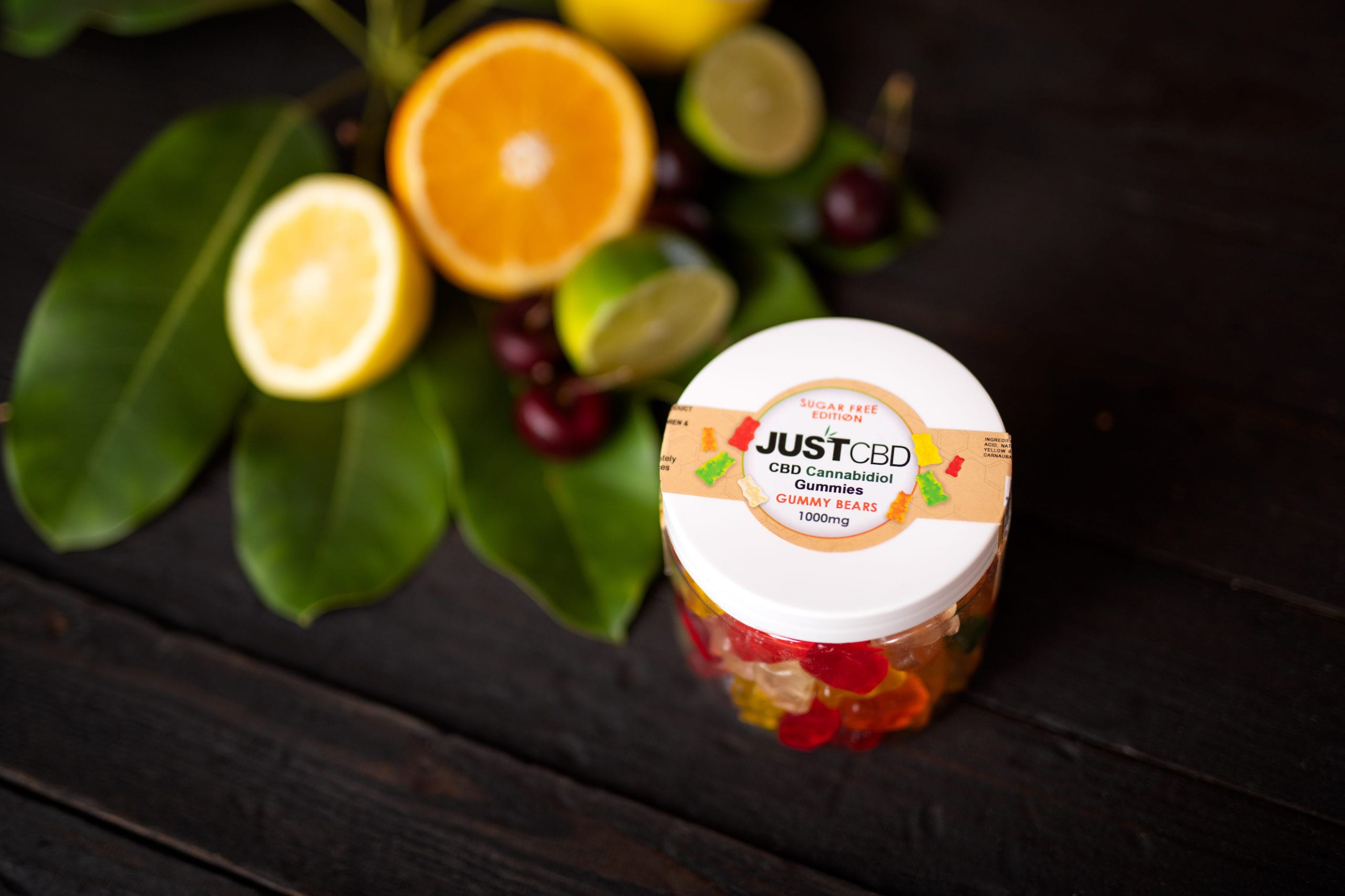IU C&I Studios Portfolio JustCBD Product Photography and Just CBD Products Sugar free gummy bears on display with citrus fruit and cherries nearby
