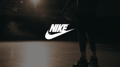 Nike Sneakers Conceptual Advertisement White Nike Logo With A Background Showing The Lower Half Of An African American Man Poised Holding A Basketball On A Basketball Court With A Light Shining On Him In Semi Darkness