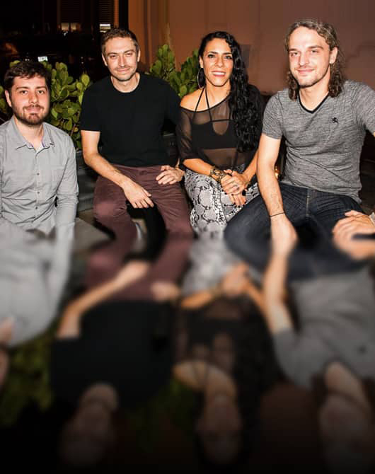 Three men and a woman posing for the camera