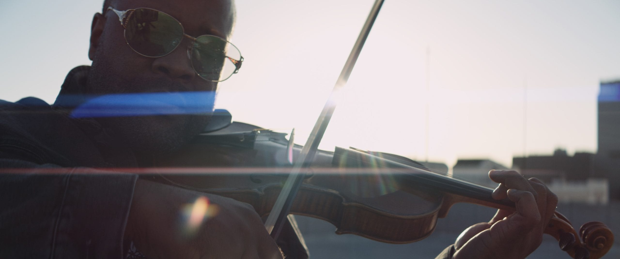 Black Violin One Step Music Video Closeup of man wearing shades playing a violin