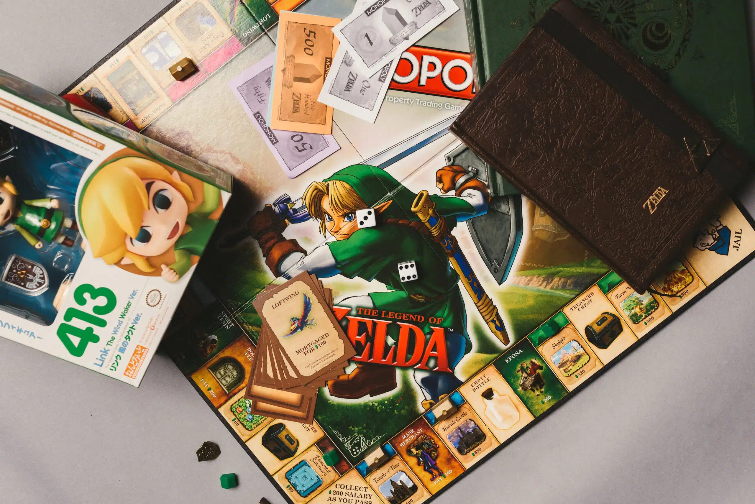 Heart Piece Plus 8 Zelda and Monopoly board games on display with Zelda book
