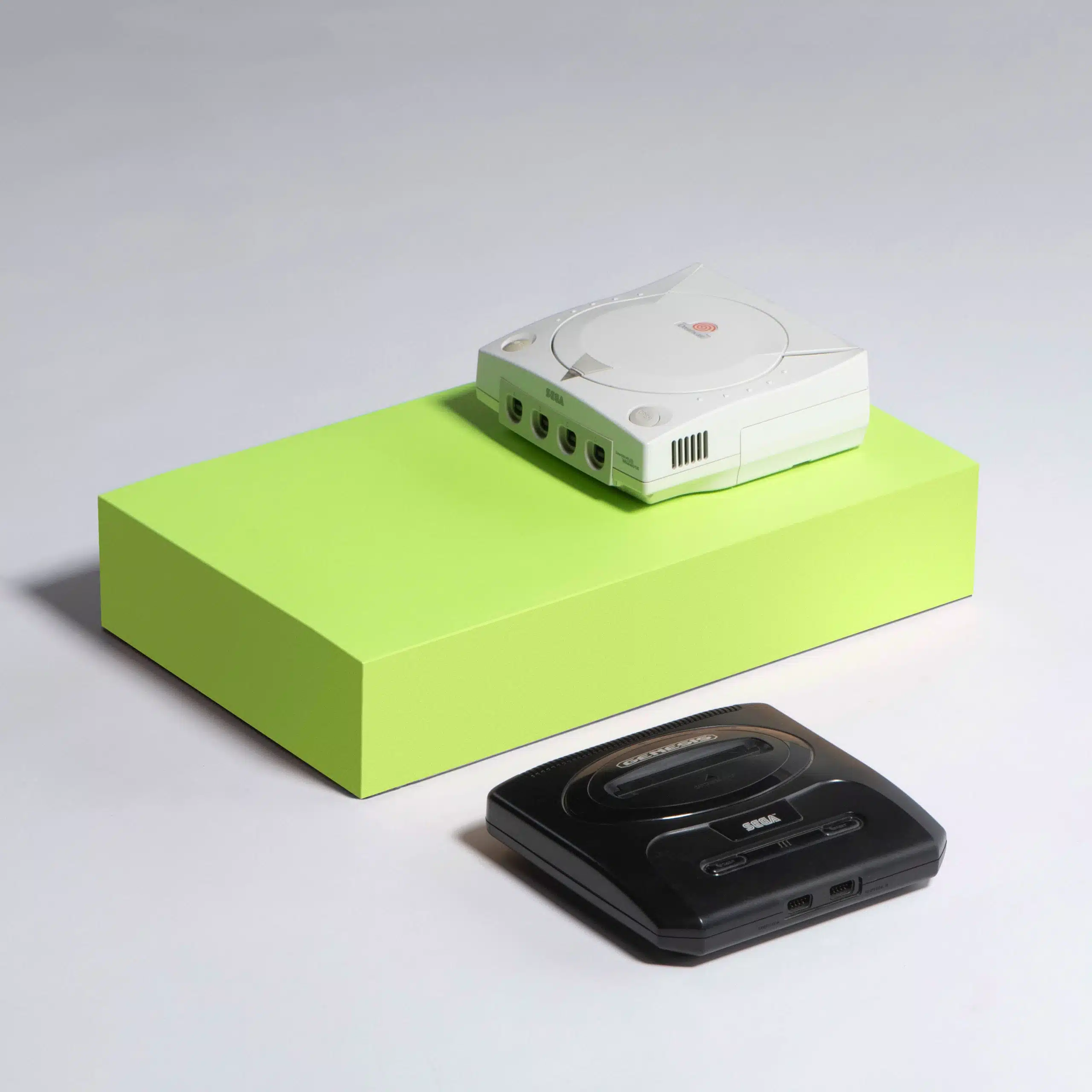 Heart Piece Plus 19 Old Sega gaming console on a green box with another Sega console nearby