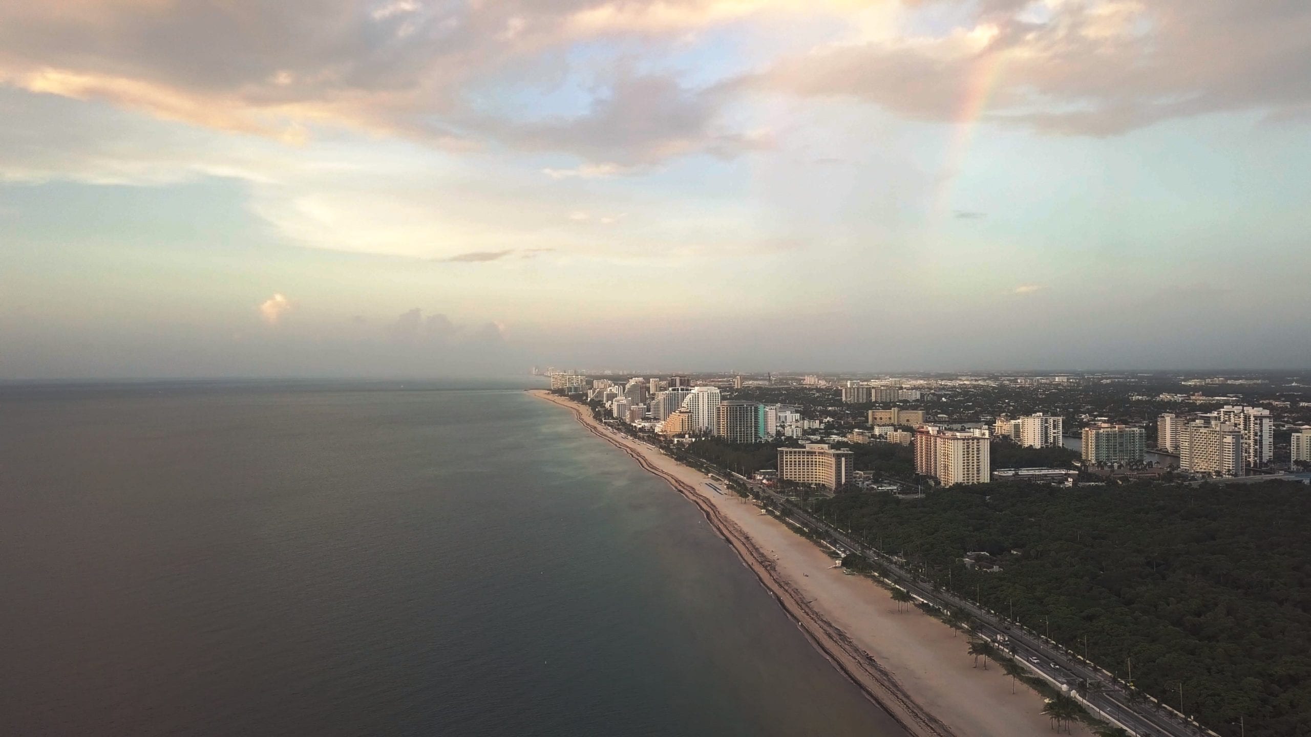 Beach coastline view by water with city in the background