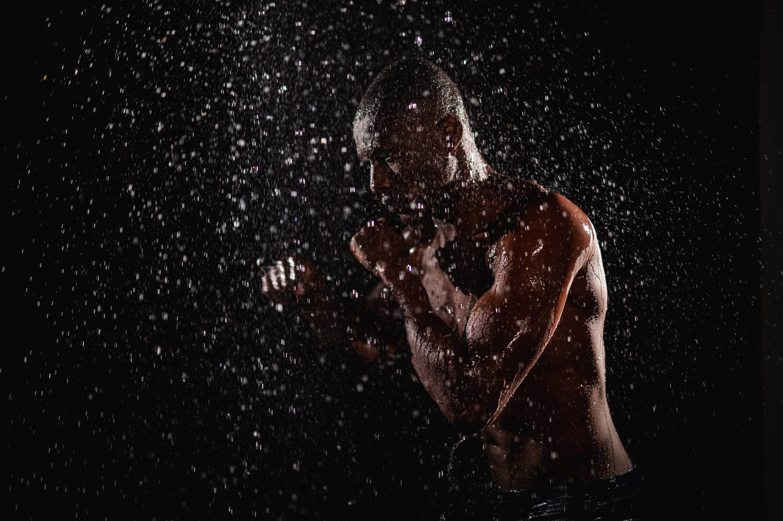 Crew Call Rain and Water Side profile of a muscular man in a boxing pose in a shower of water