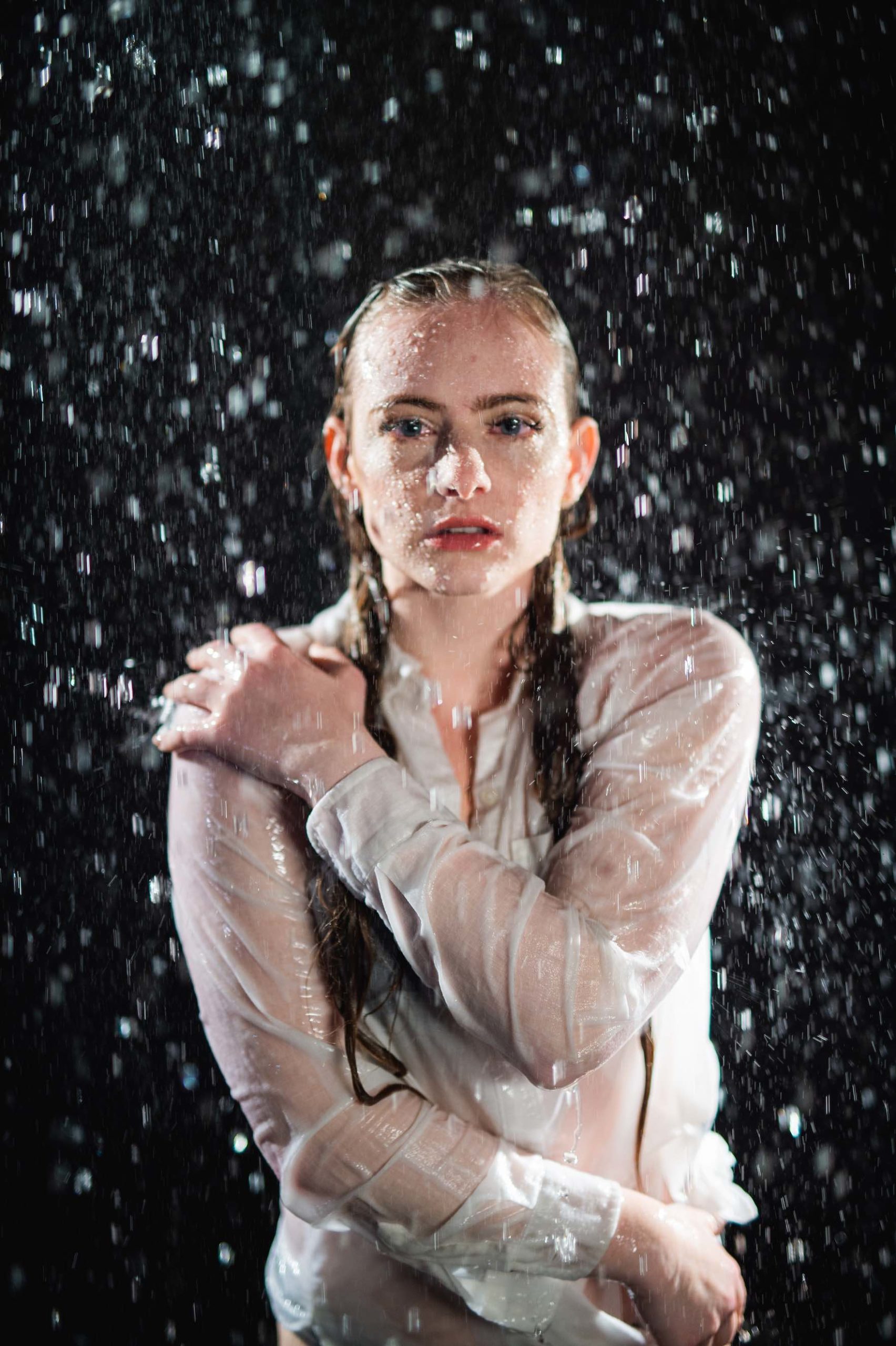 Crew Call Rain and Water Woman with long hair and soaked through white shirt posing for the camera under a shower of water