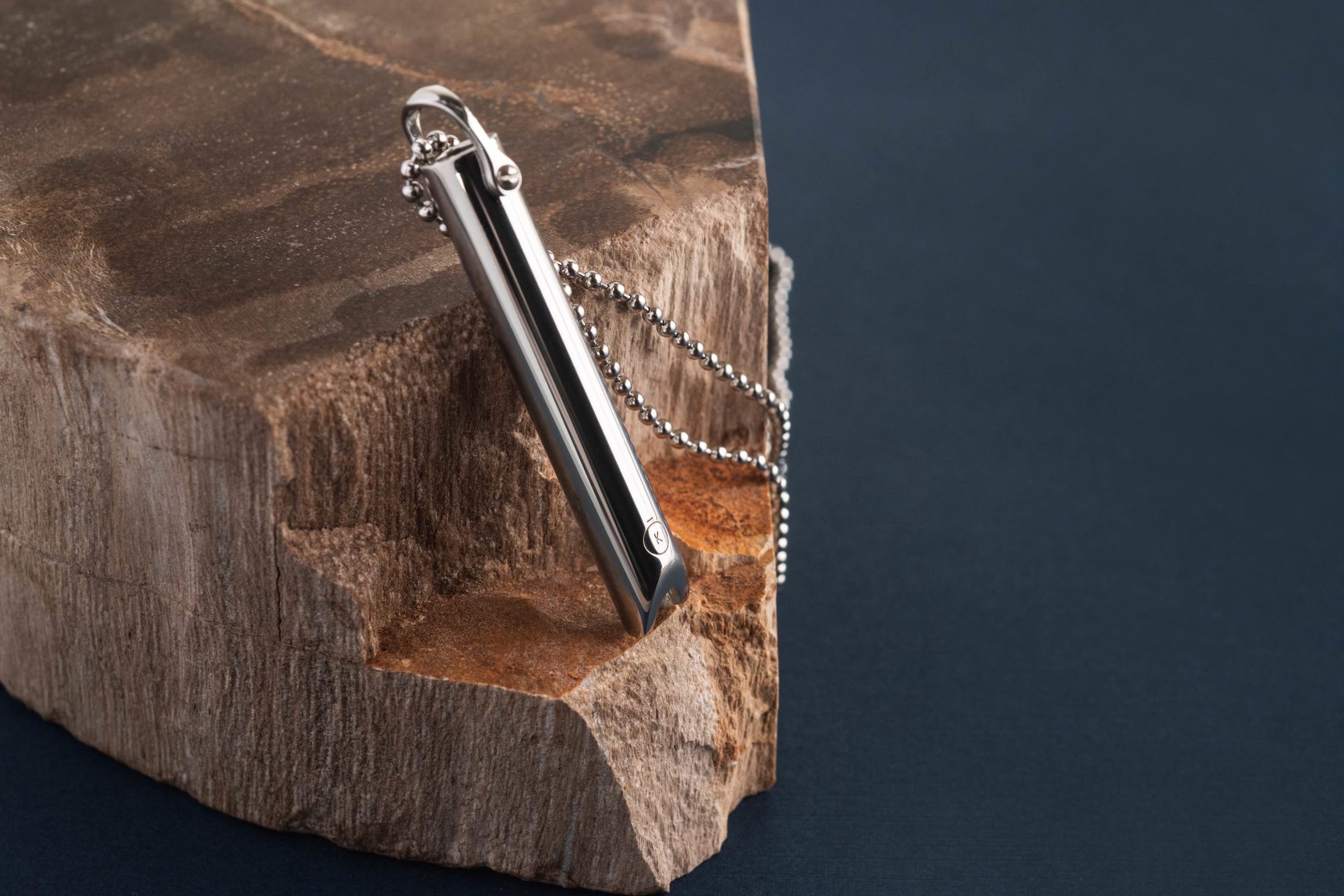 Komuso Design Photography Closeup of silver colored whistle on a wooden block