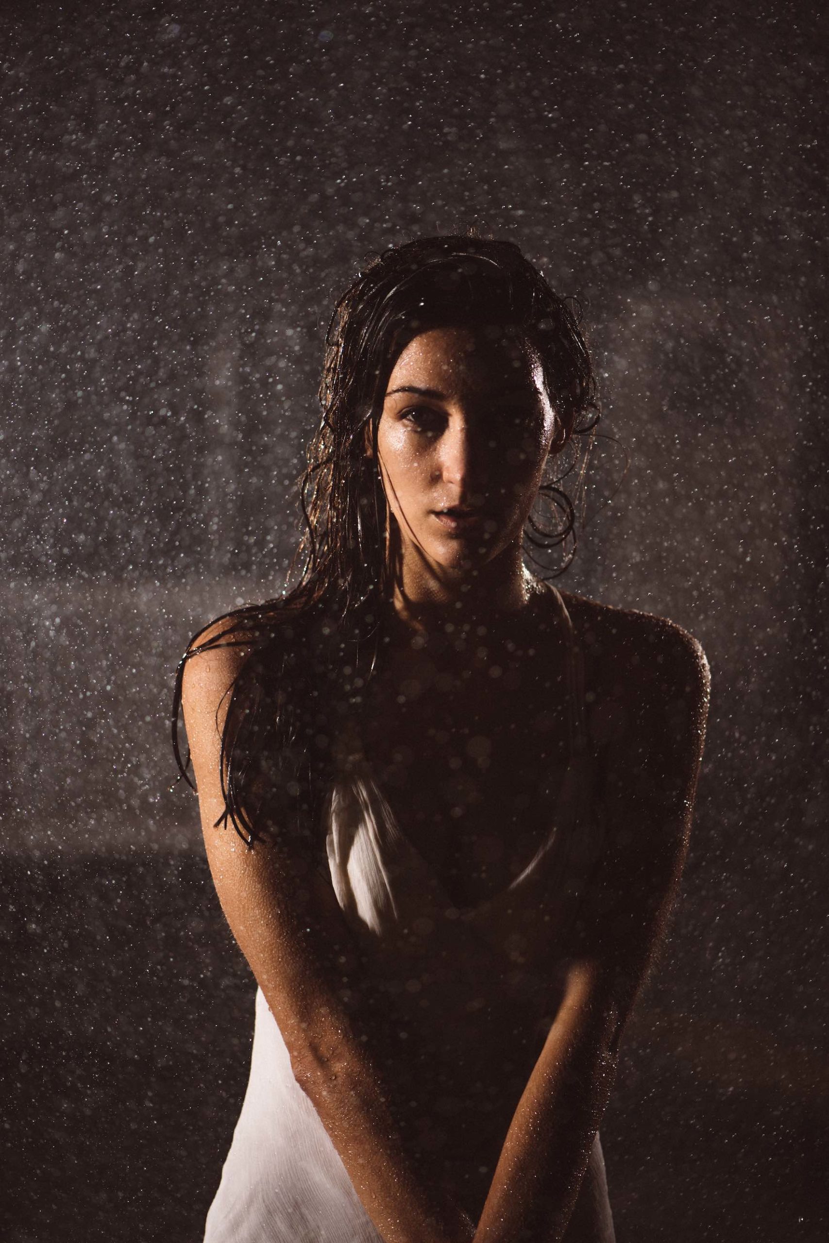 Crew Call Rain and Water Woman with long hair posing for camera under a shower of water