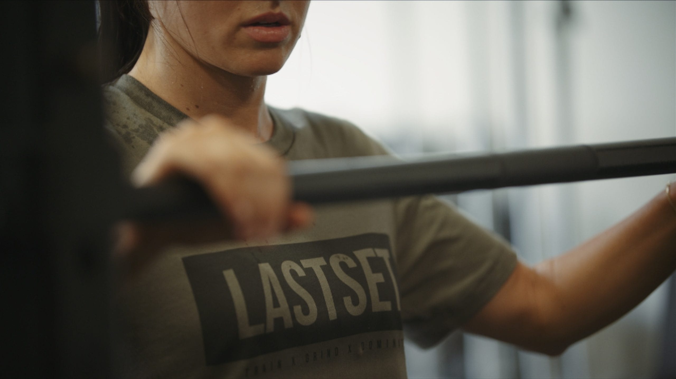 IU C&I Studios Portfolio LastSet Clothing Line Brand Video Closeup of woman in a gray t shirt holding weight bar
