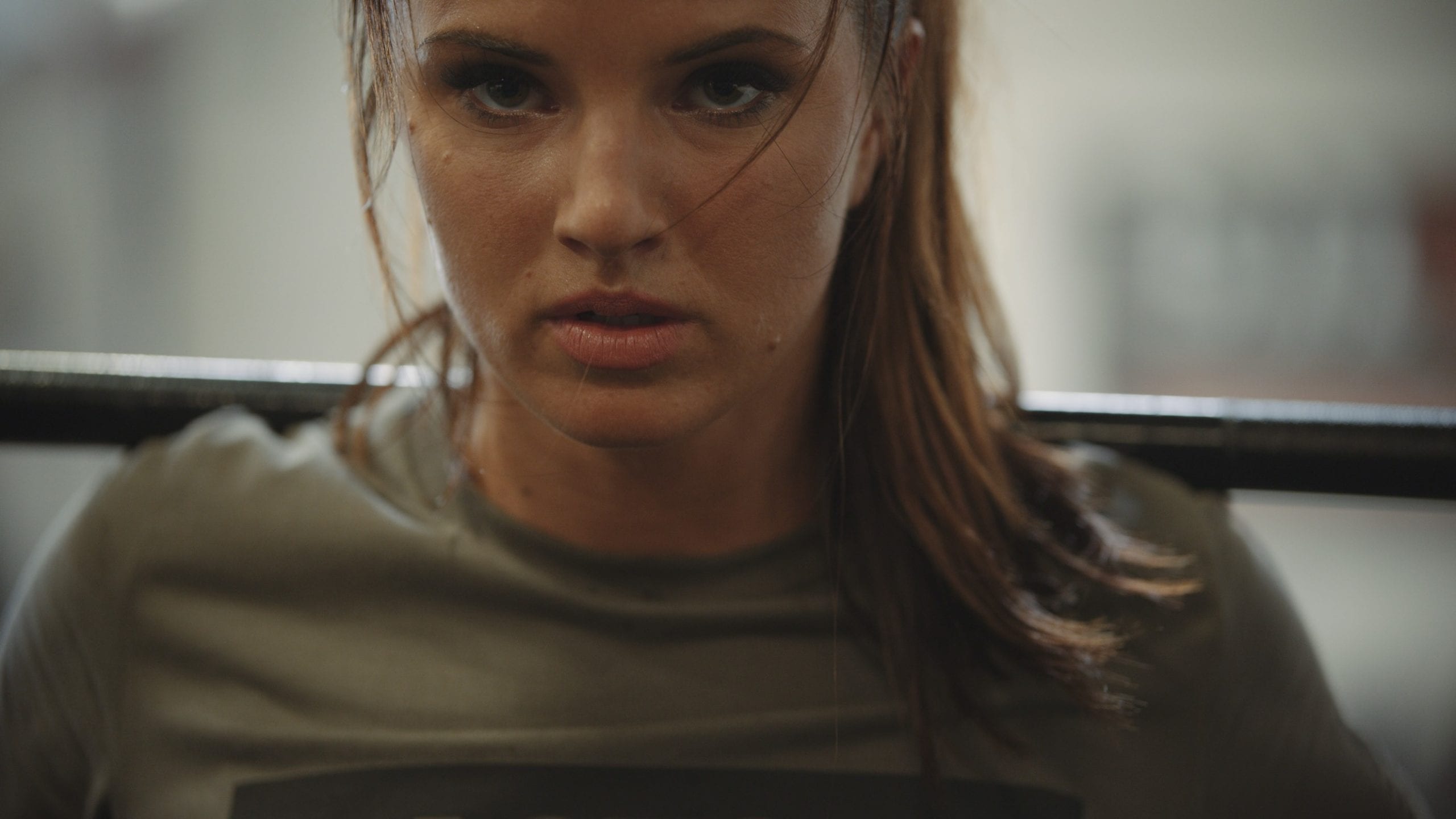 IU C&I Studios Portfolio LastSet Co Closeup of woman wearing a gray t shirt lifting weight