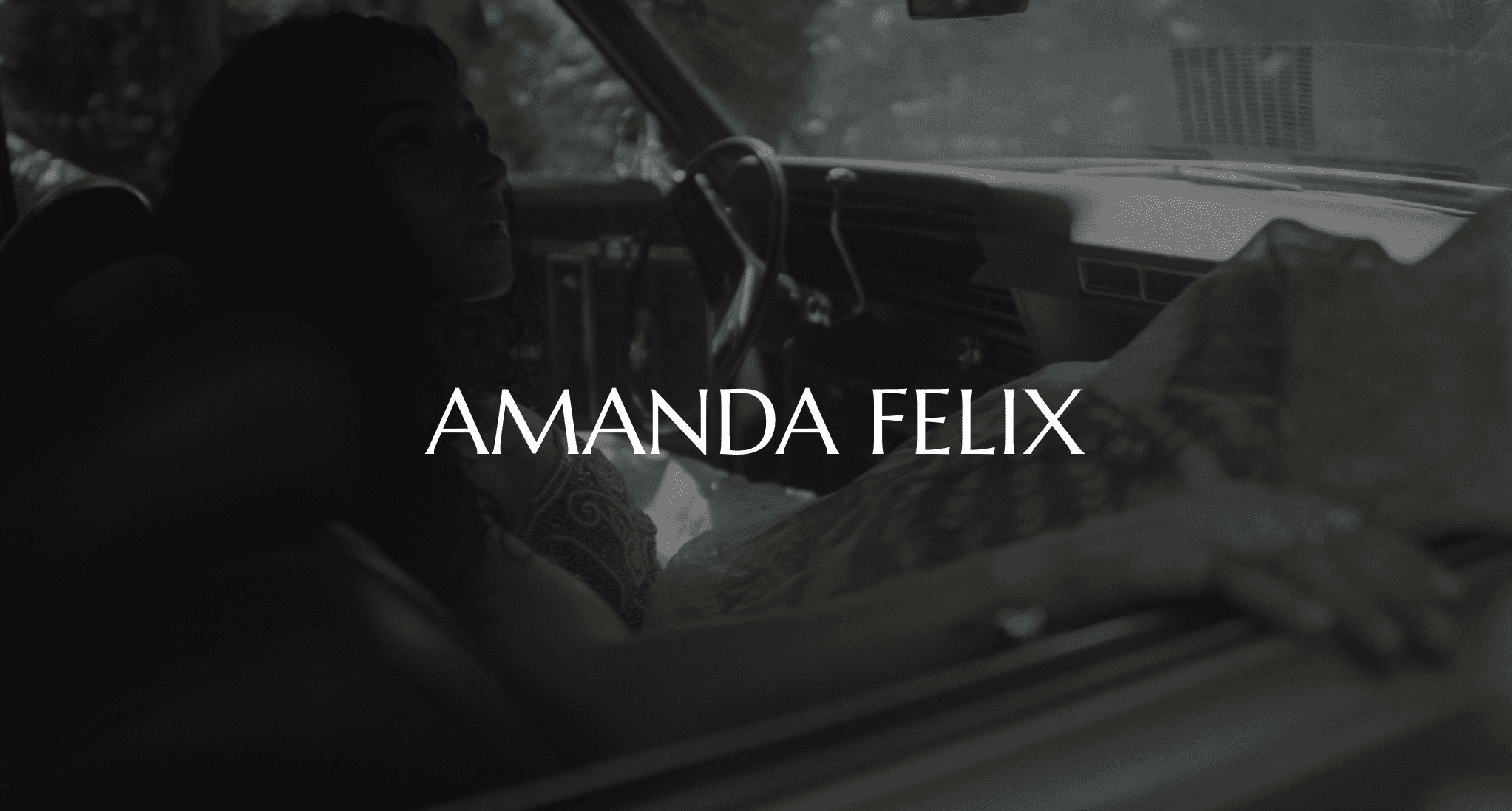White Amanda Felix logo with black and white background of a woman lounging in a car looking out with hand on the door
