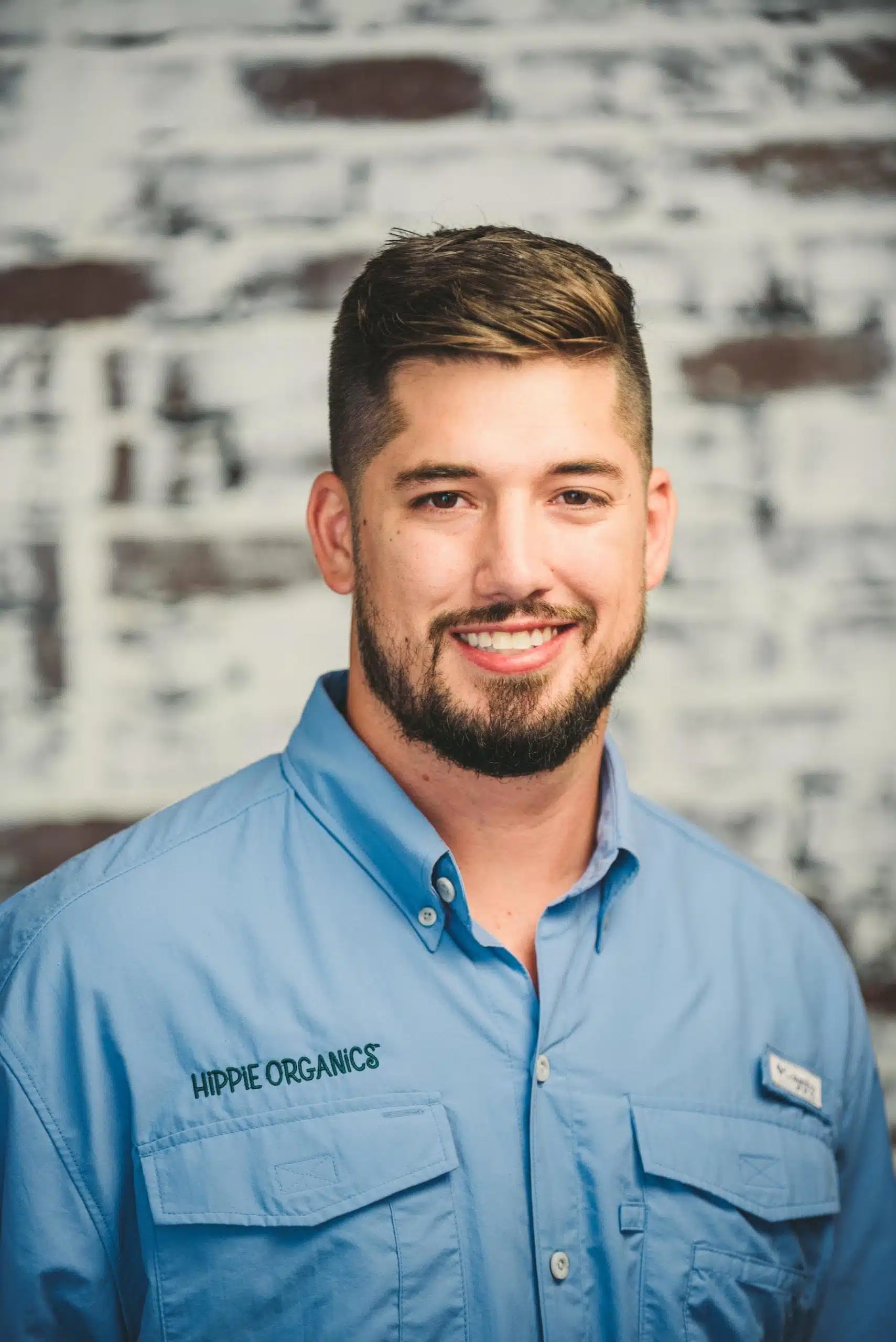 Hippie Organics by Alpine Fresh 17 Headshot of male Hippee Organics employee with brown short hair and beard wearing blue uniform