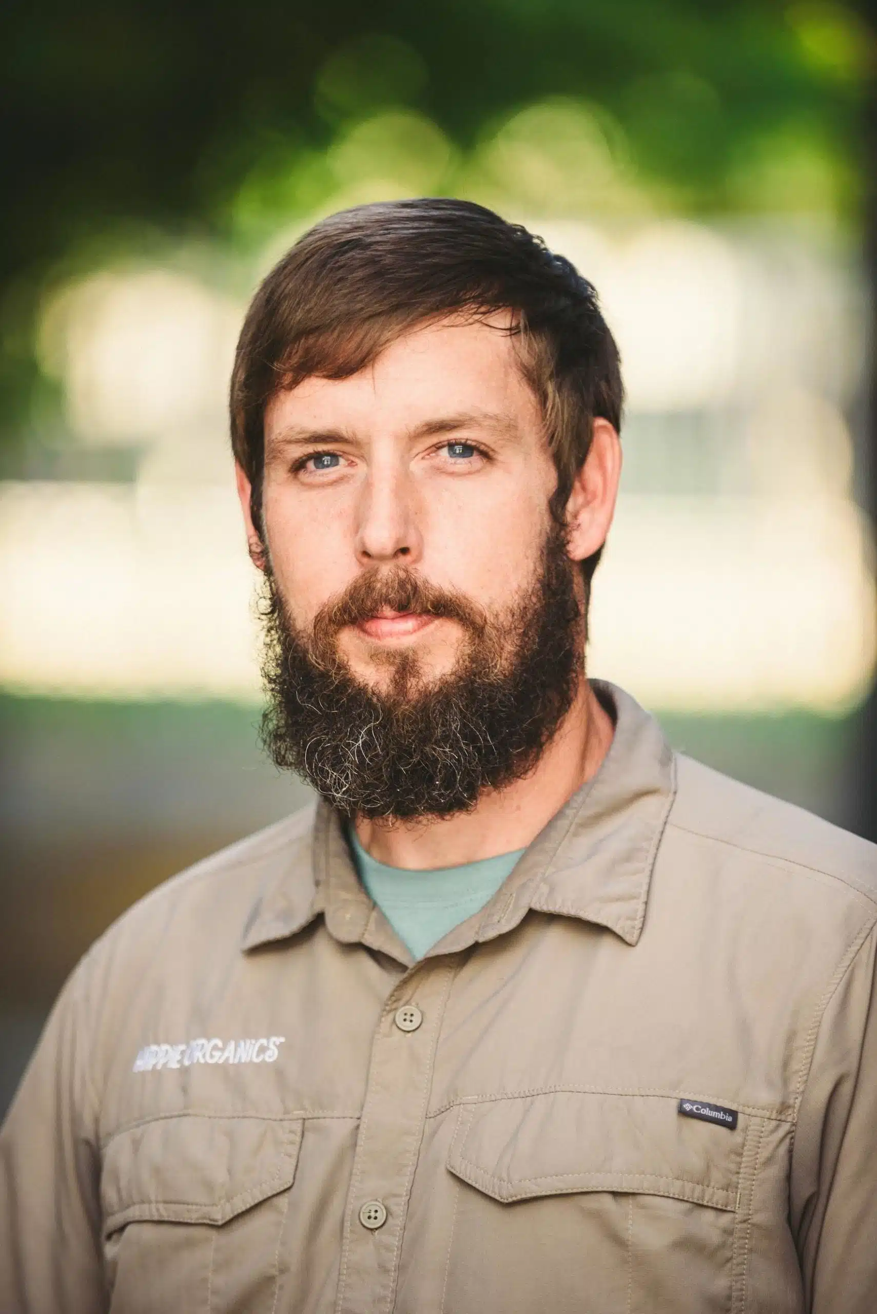 Hippie Organics by Alpine Fresh 19 Headshot of male Hippee Organics employee with brown short hair and beard wearing beige uniform
