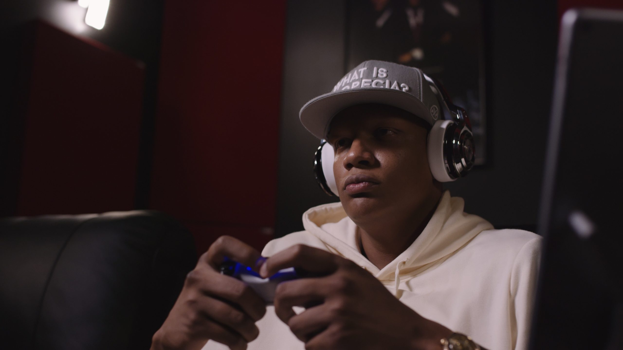 Monster Music Charlie Villanueva African American man wearing headphones and black cap using a video game controller