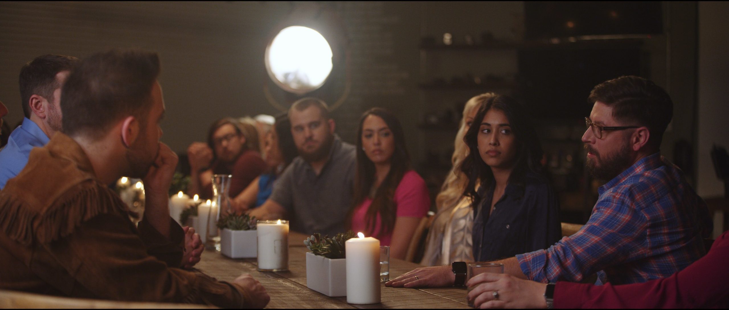 MRINetwork Company Video Lets Start Building Group of people talking at a wooden table with white candles and planters