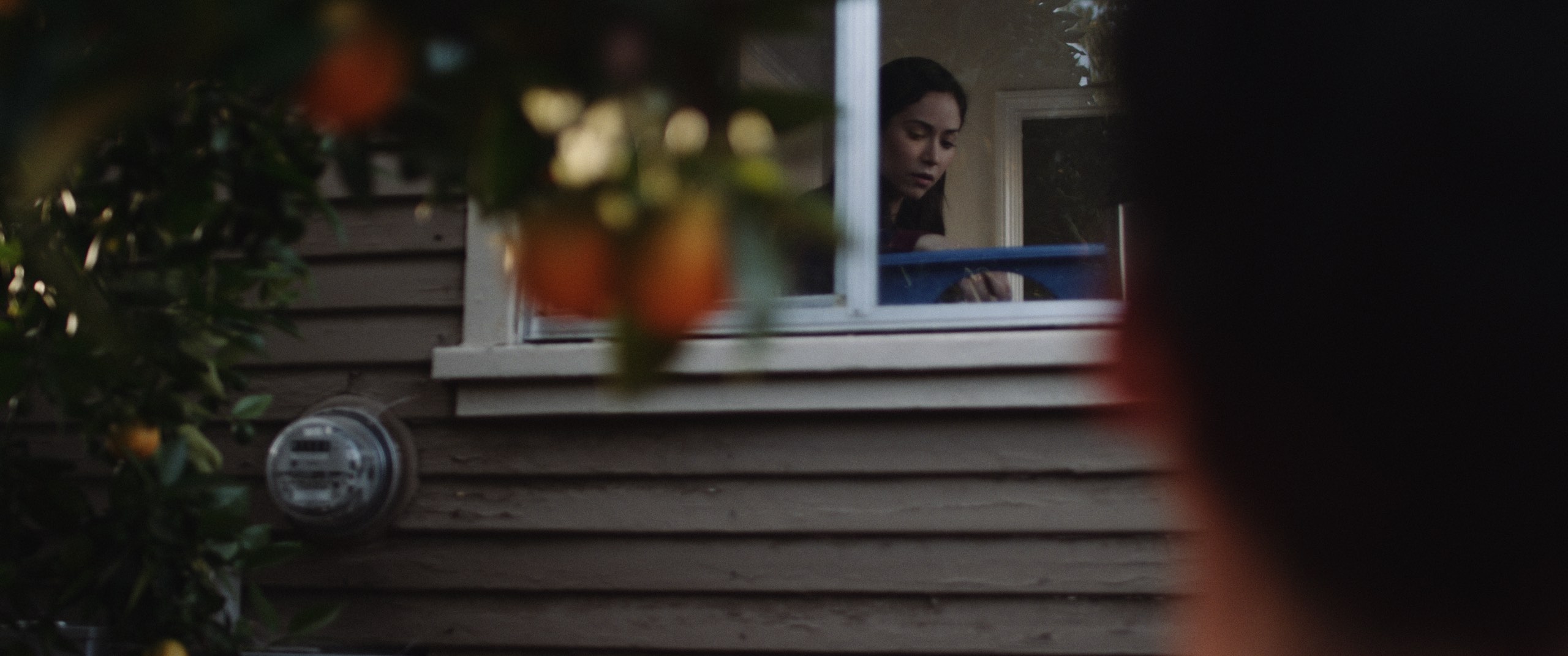 Grace From Above, A C&I Studios Original Short Film View from behind of man looking into window of house at a woman