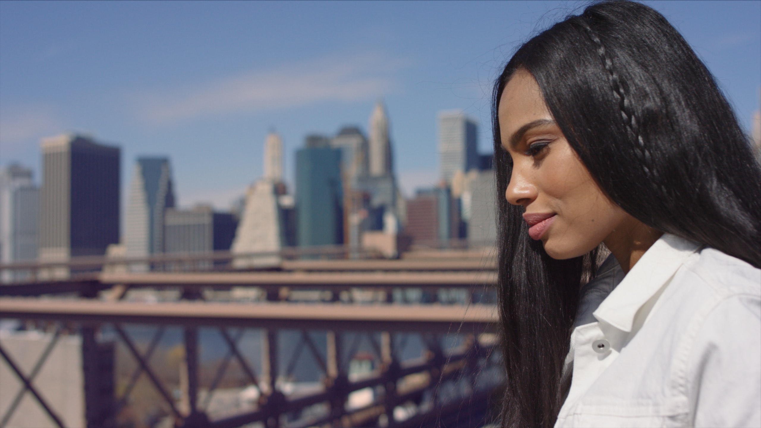 BTS Haute House Shoot Dailies 0058 Side profile of woman with long black hair wearing a white dress shirt with city in the background