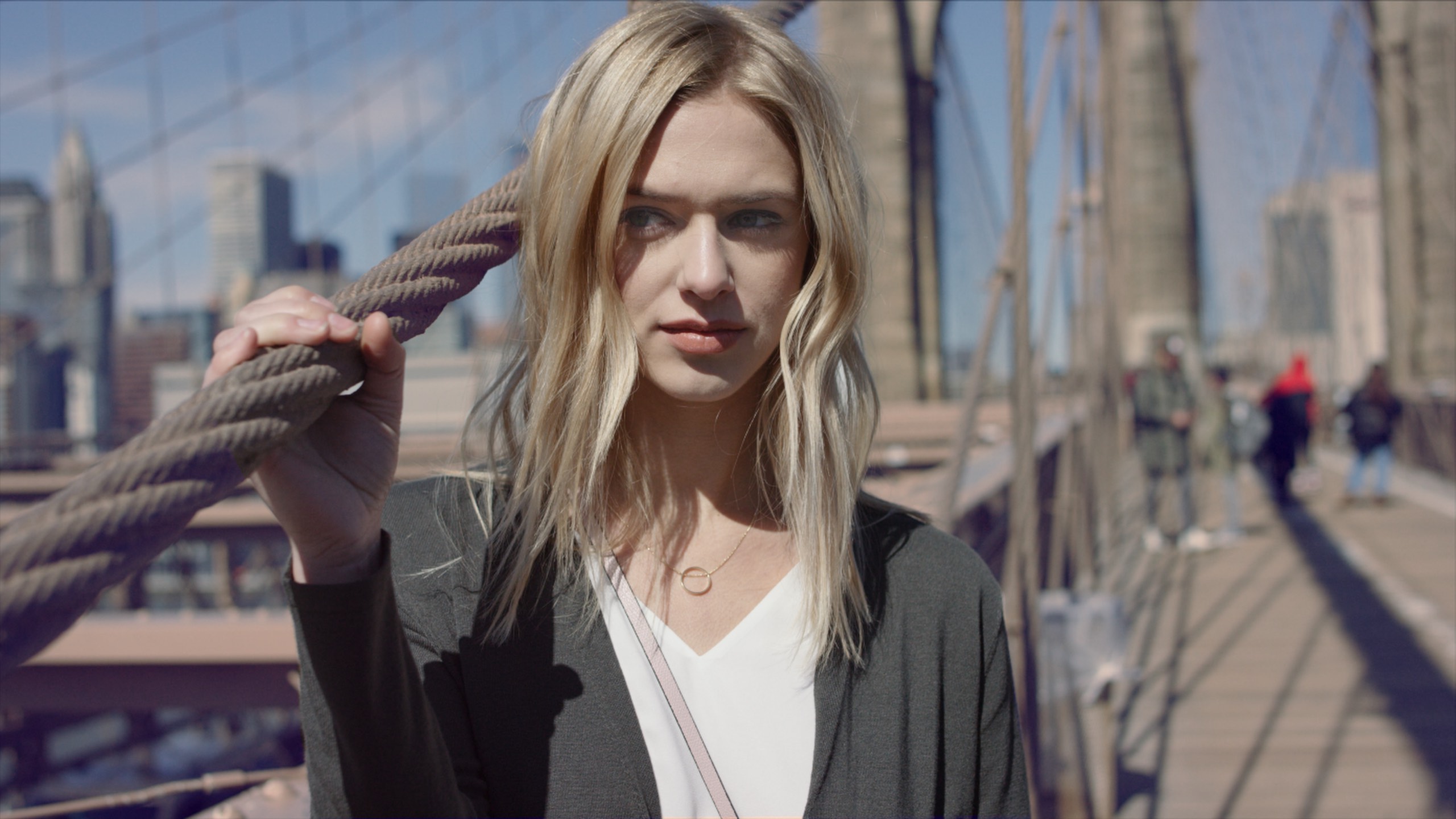 BTS Haute House Shoot Dailies 0058 Headshot of woman with long blond hair holding a rope on a bridge in the city