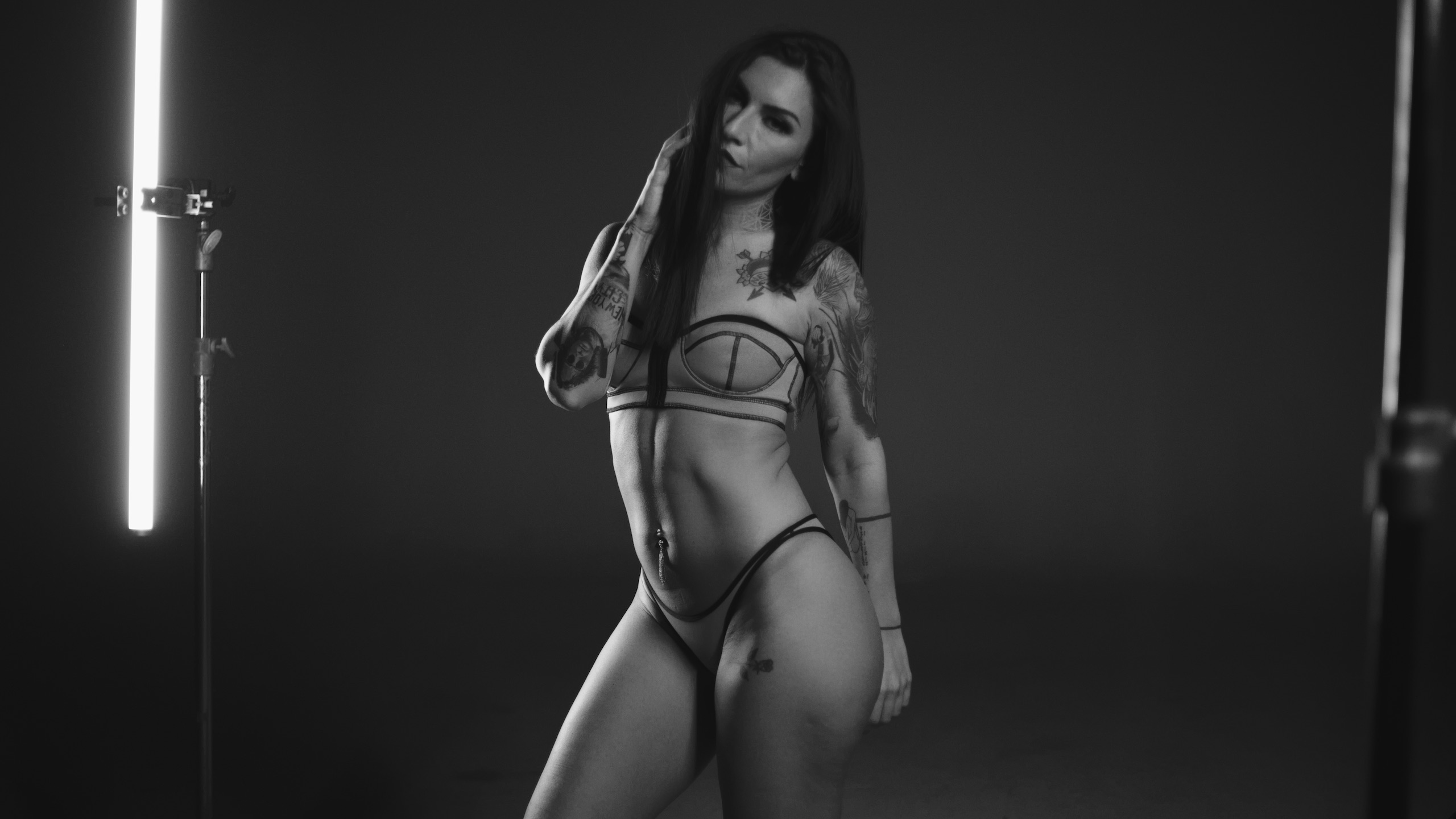 Puma Crew Call the Tattoo Project Black and white view of tattooed woman wearing bikini and thong under lights