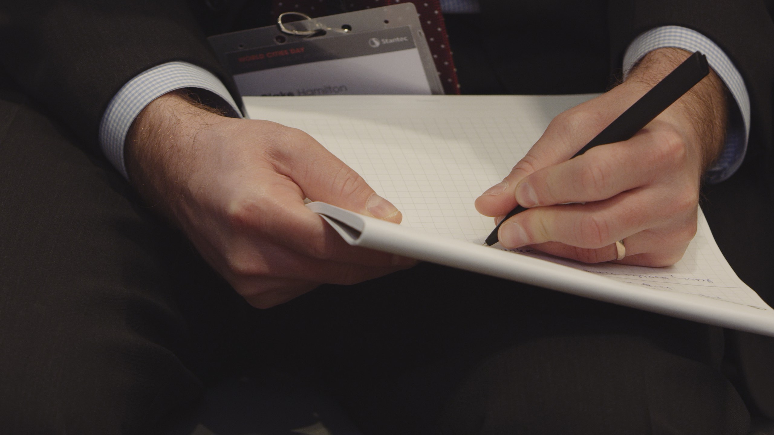 IU C&I Studios Portfolio Stantec UK and NY Livestream International Live Streaming Event Closeup of man writing notes in a notebook with a black pen