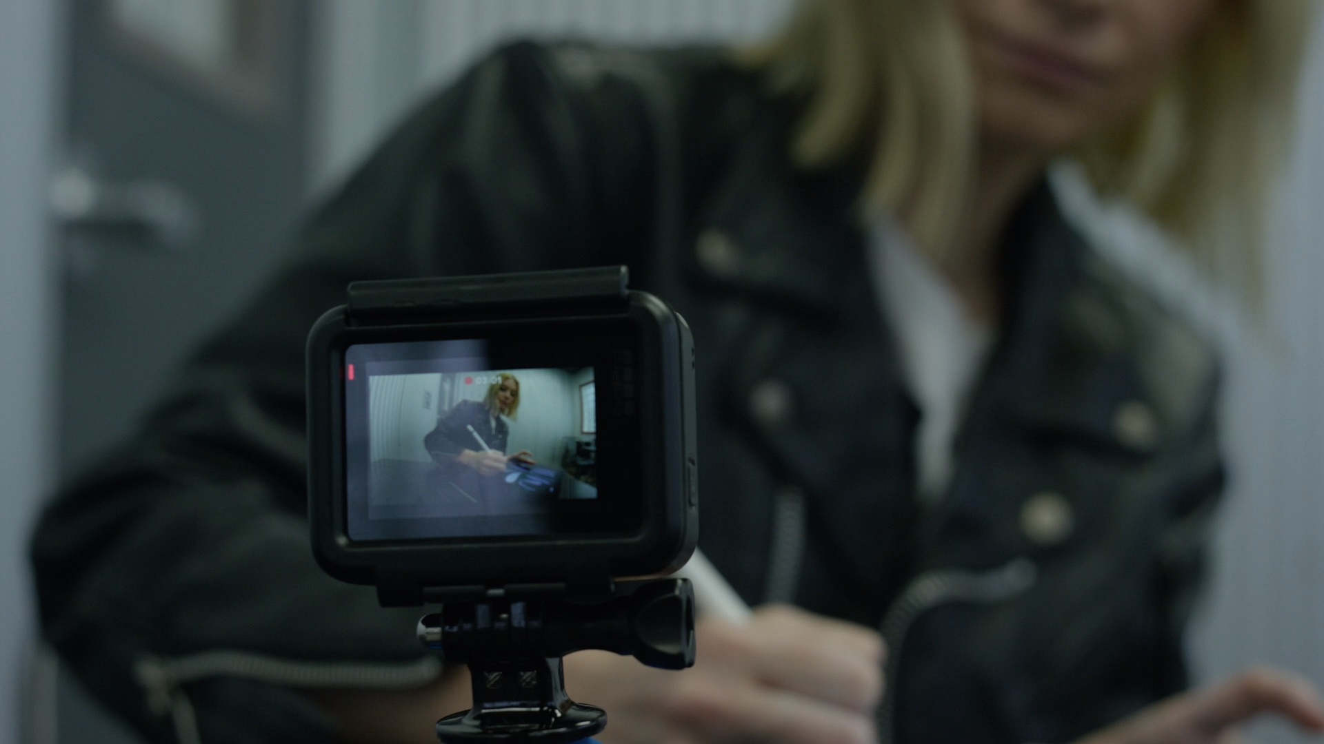 Closeup of video camera display of Molly Pledge writing something with a pen