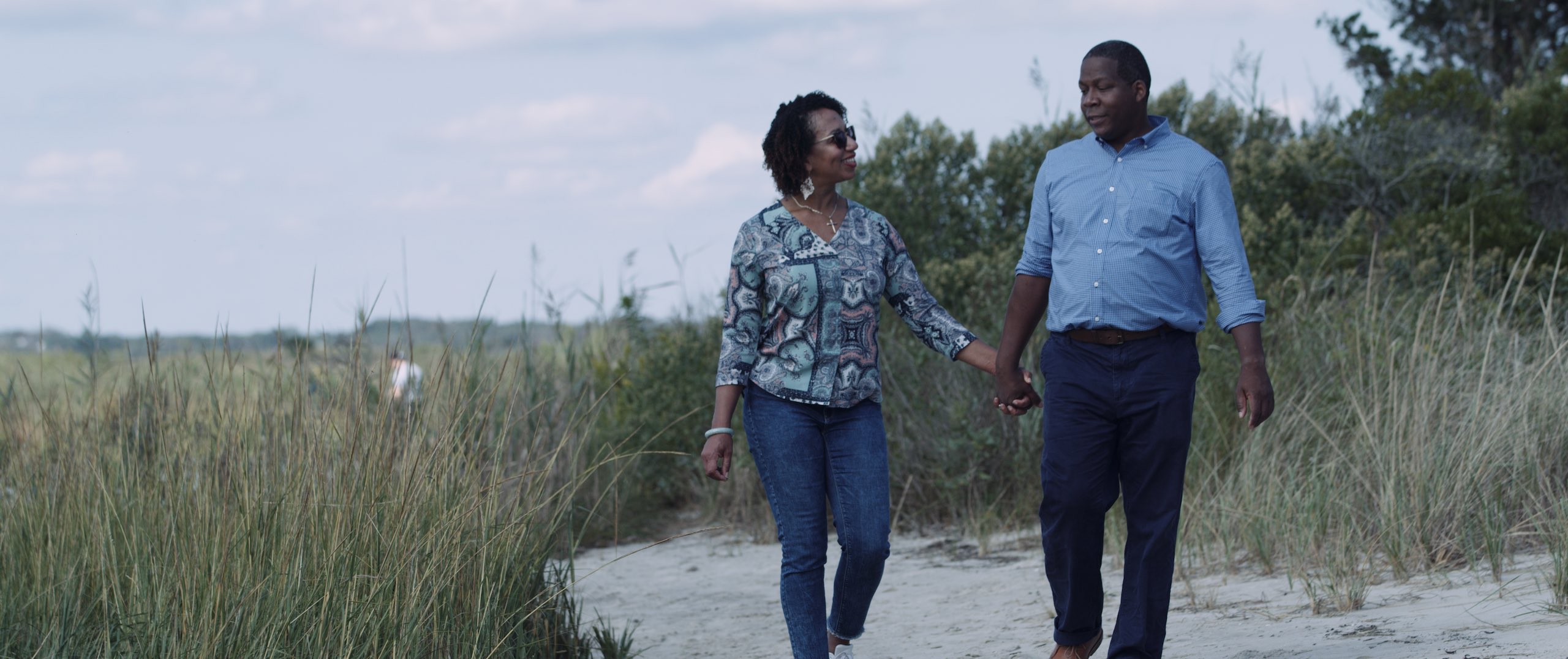 Dailies Political season with 76 Words African American man and woman walking in the sand dunes holding hands