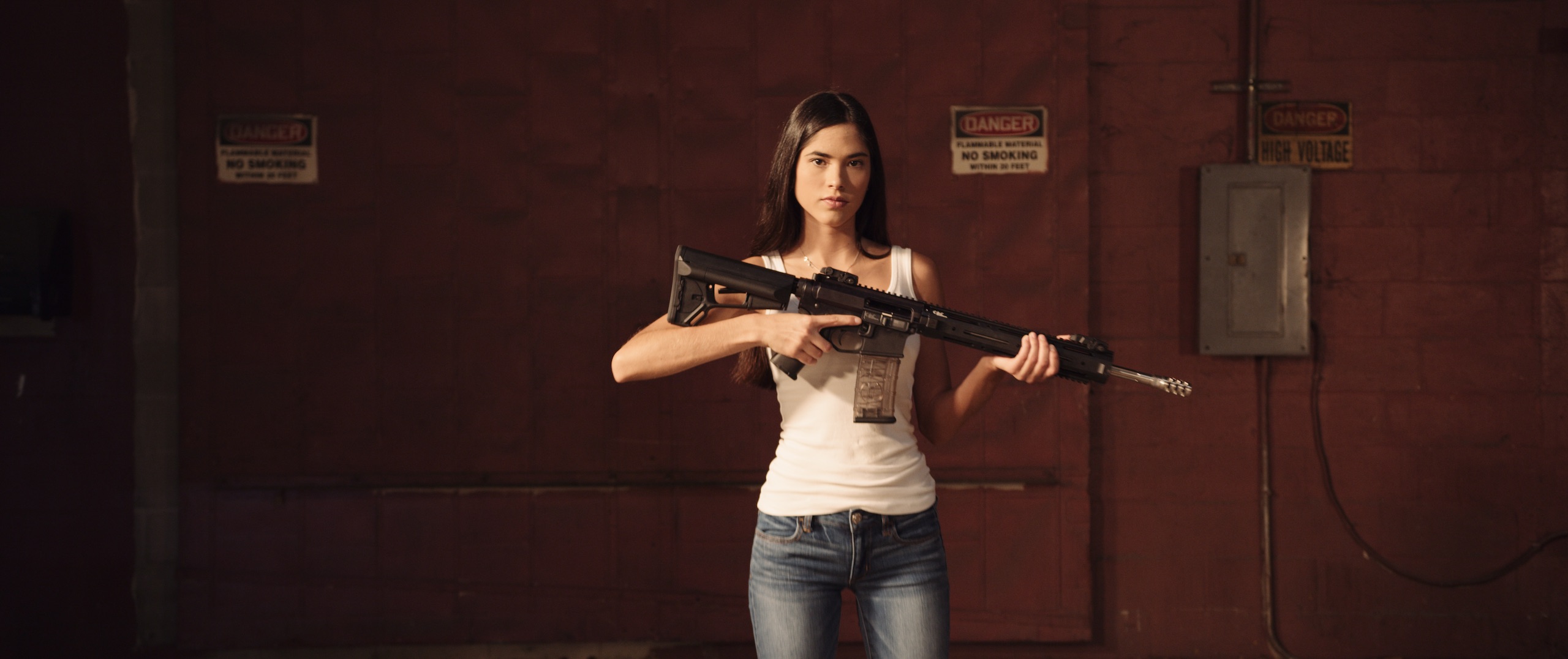 Dailies Political season with 76 Words Woman with long brown hair wearing a white tank top and jeans holding a rifle in a studio