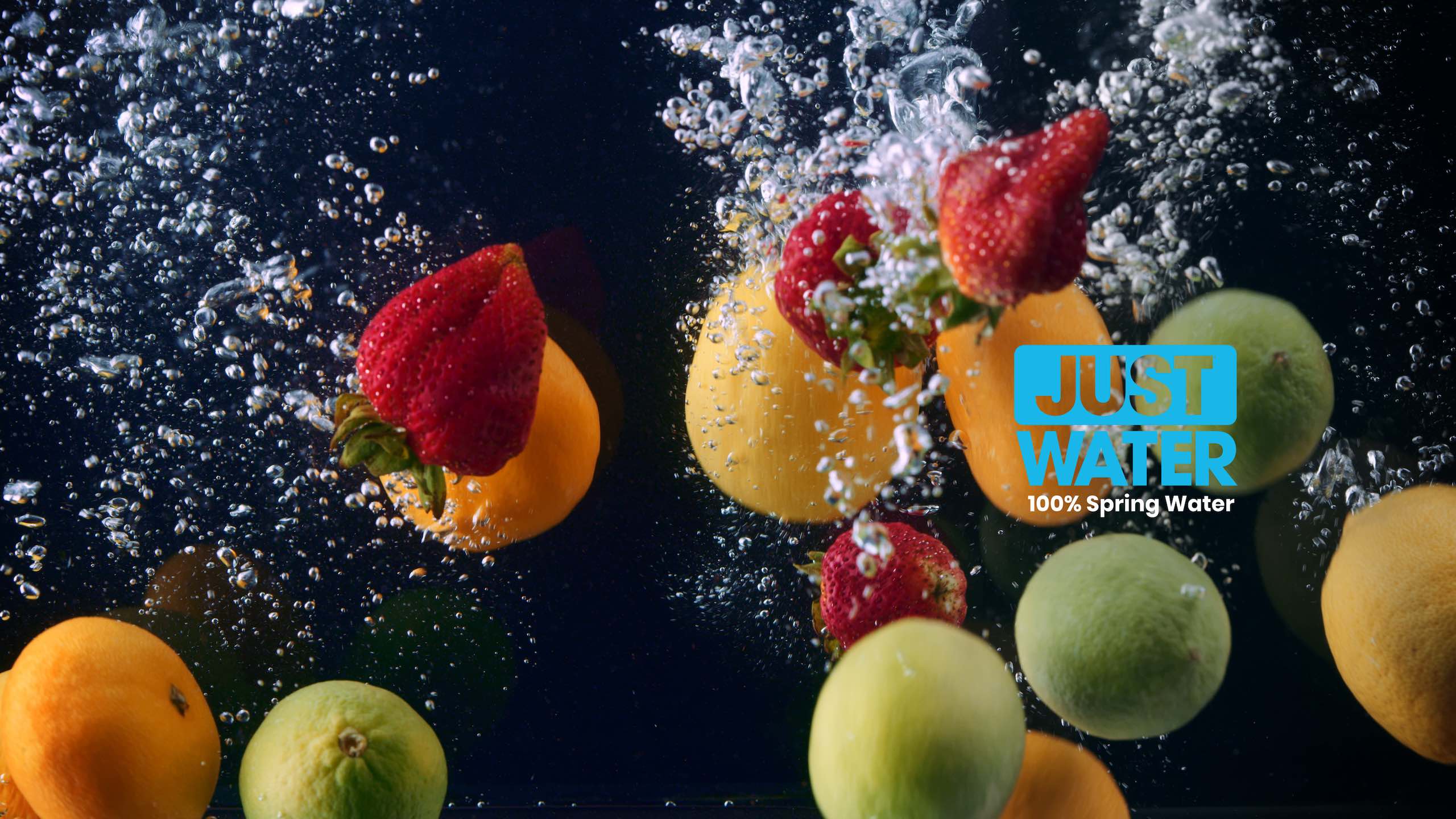Just water video ad Tangerines, strawberries and limes under water with bubbles. There is also a light blue and white logo