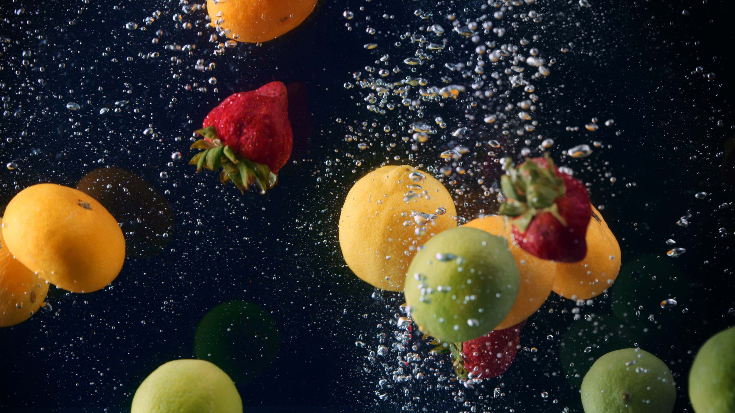 Just water video ad Tangerines, strawberries and limes under water with bubbles.