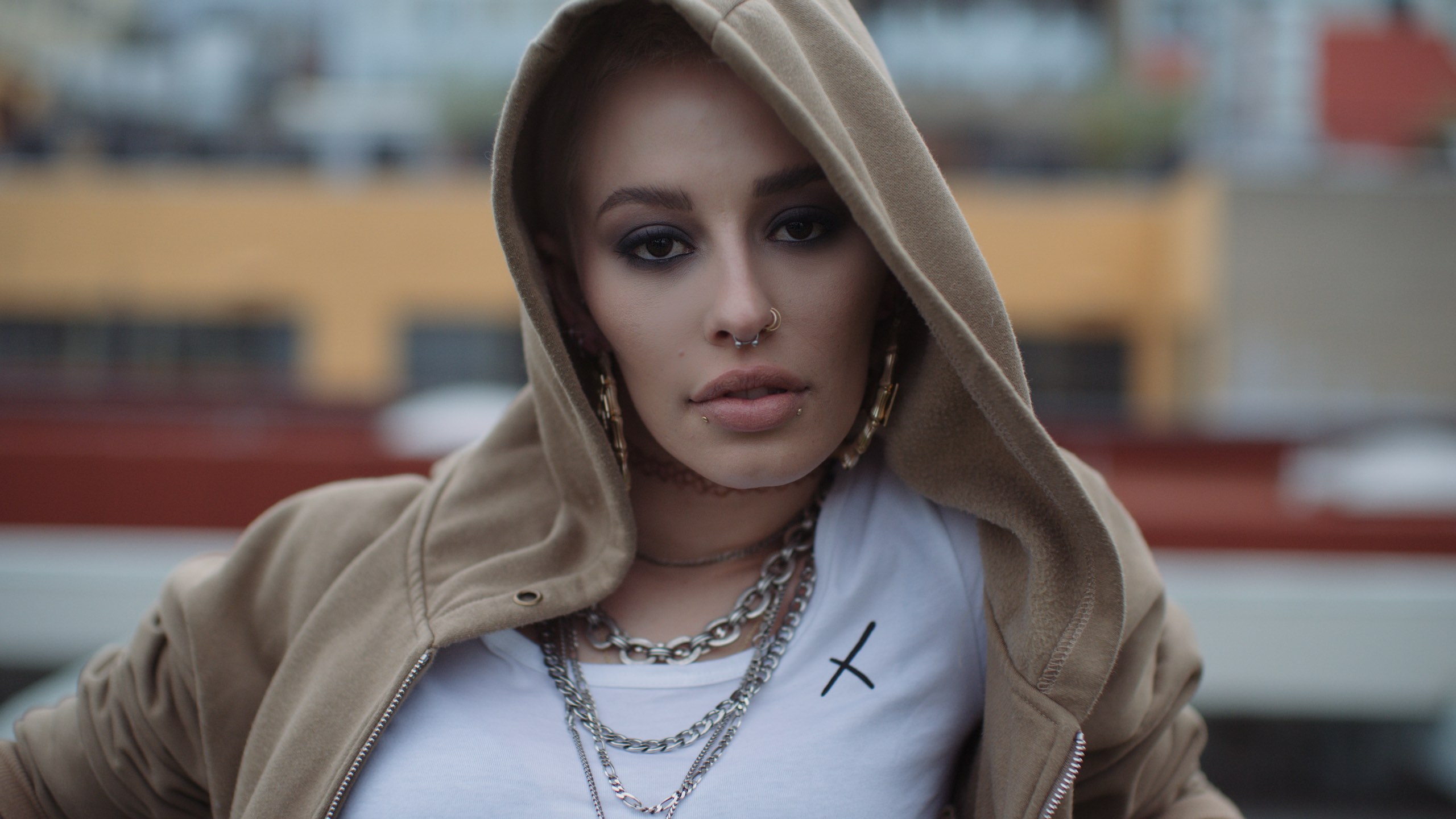 Uncreative Shop LA clothing company Headshot of woman with nose rings, earrings and chains wearing a beige hoodie
