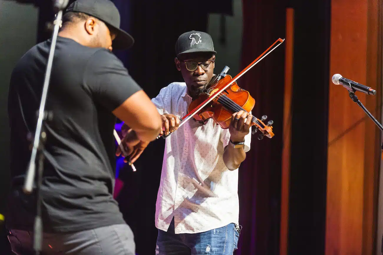 Two men playing violin on a stage