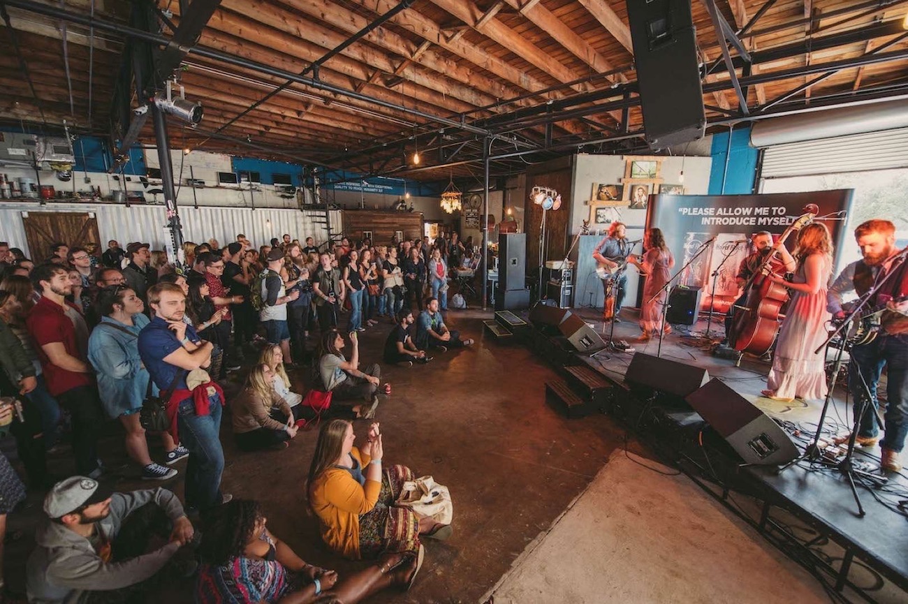 Band playing in front of a crowd in a studio