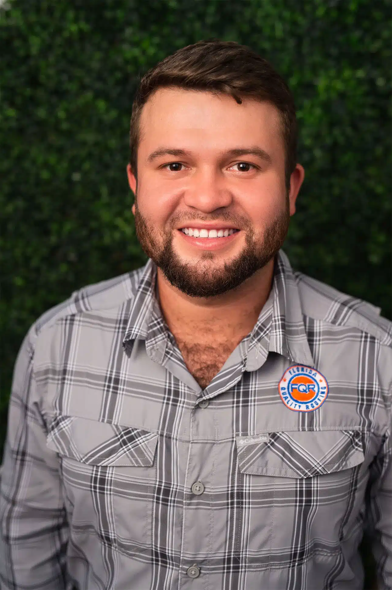 Florida Quality Roofing 11 Headshot of man with short hair and beard wearing gray shirt with FQR logo