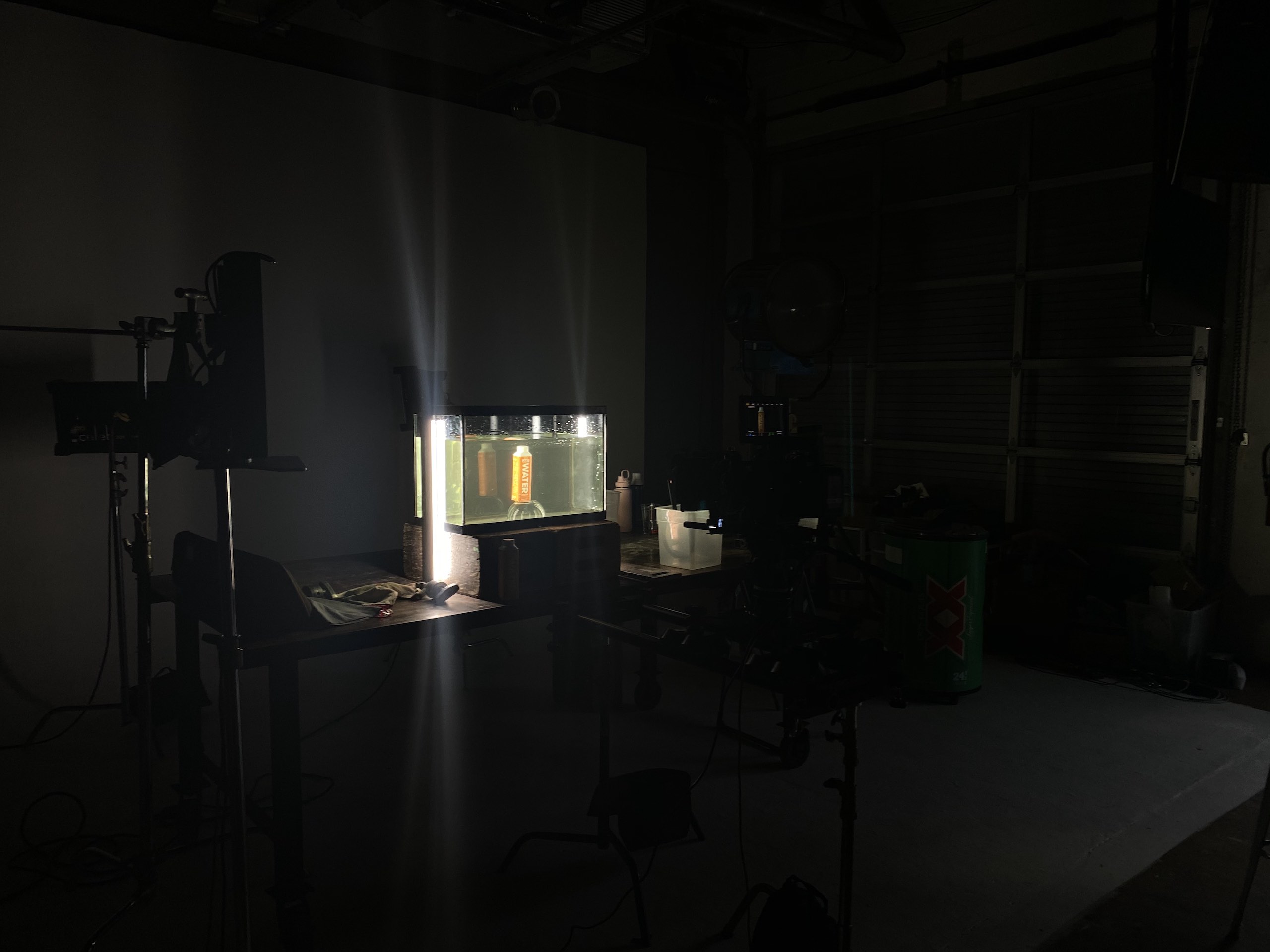 Orange drink carton under water in a tank filled with water in a studio in semidarkness