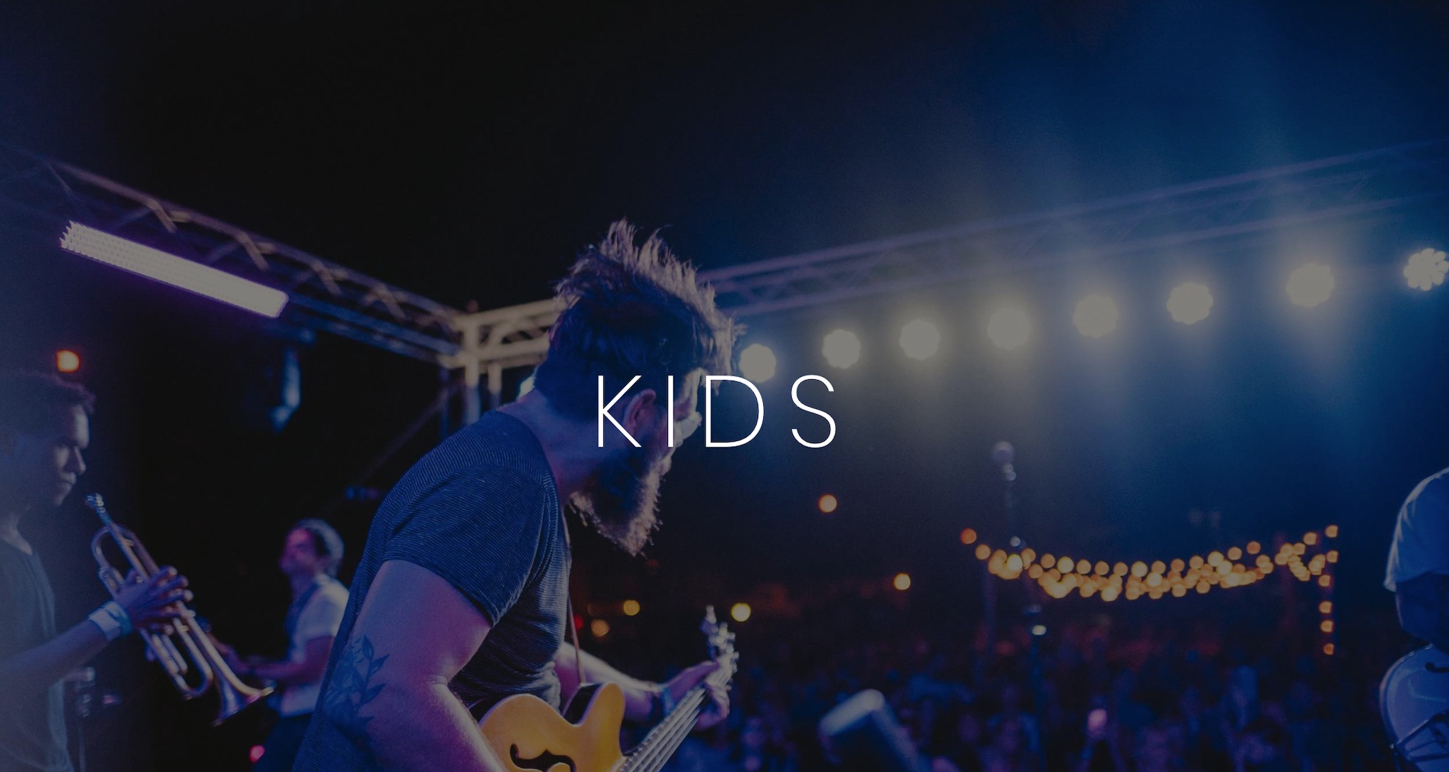 Keyword: Artist Management Services .KIDS Artist Management Services White KIDS logo on background of band playing for an audience