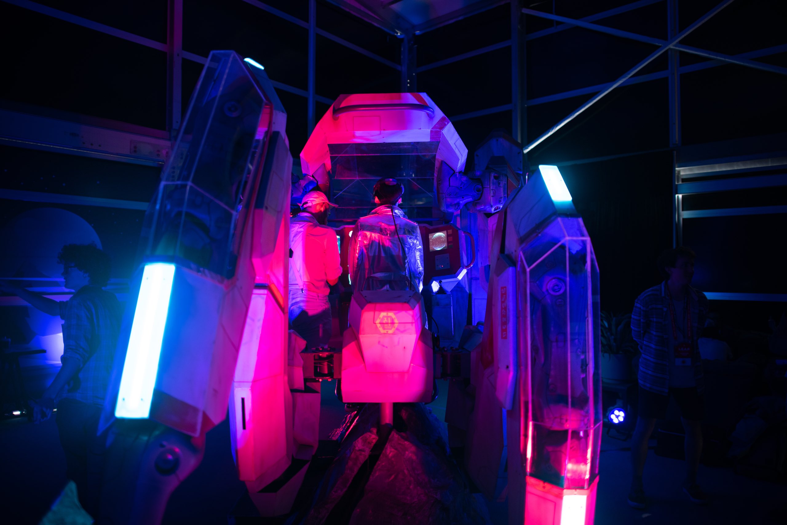 IU C&I Studios Portfolio Two people in a futuristic simulator in reddish and bluish lights
