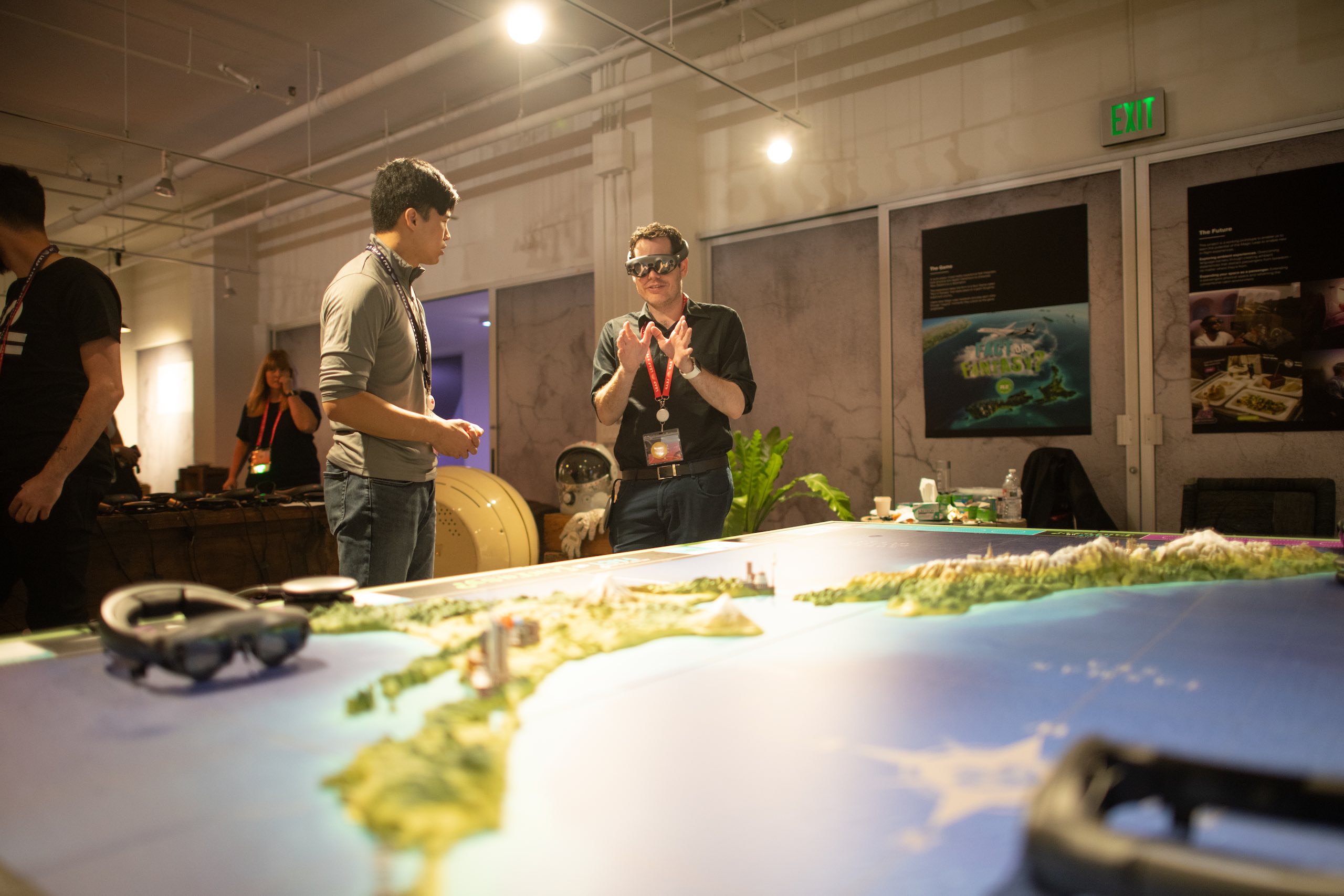 Man wearing Lightwear equipment talking to another man in front of a map model