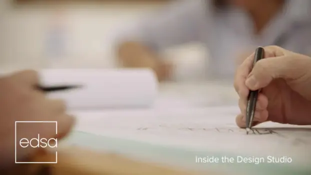 Corporate and Commercial Video Production 6 White EDSA Video Production Services Logo on dimmed background of hand making a design on a piece of paper with a black pen